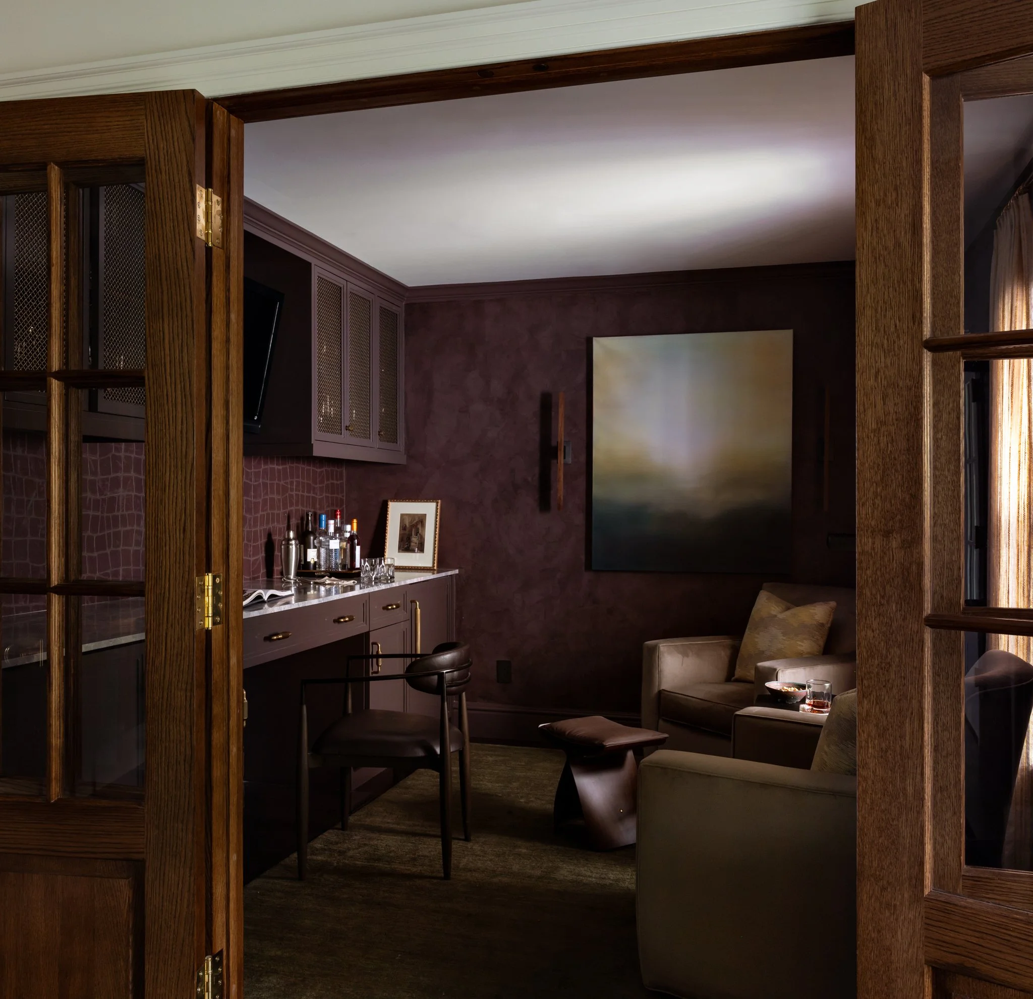 A moody man cave or office in deep plum with leather chair and bar photographed by AD 100 NYC interiors hospitality lifestyle photographer Regan Wood