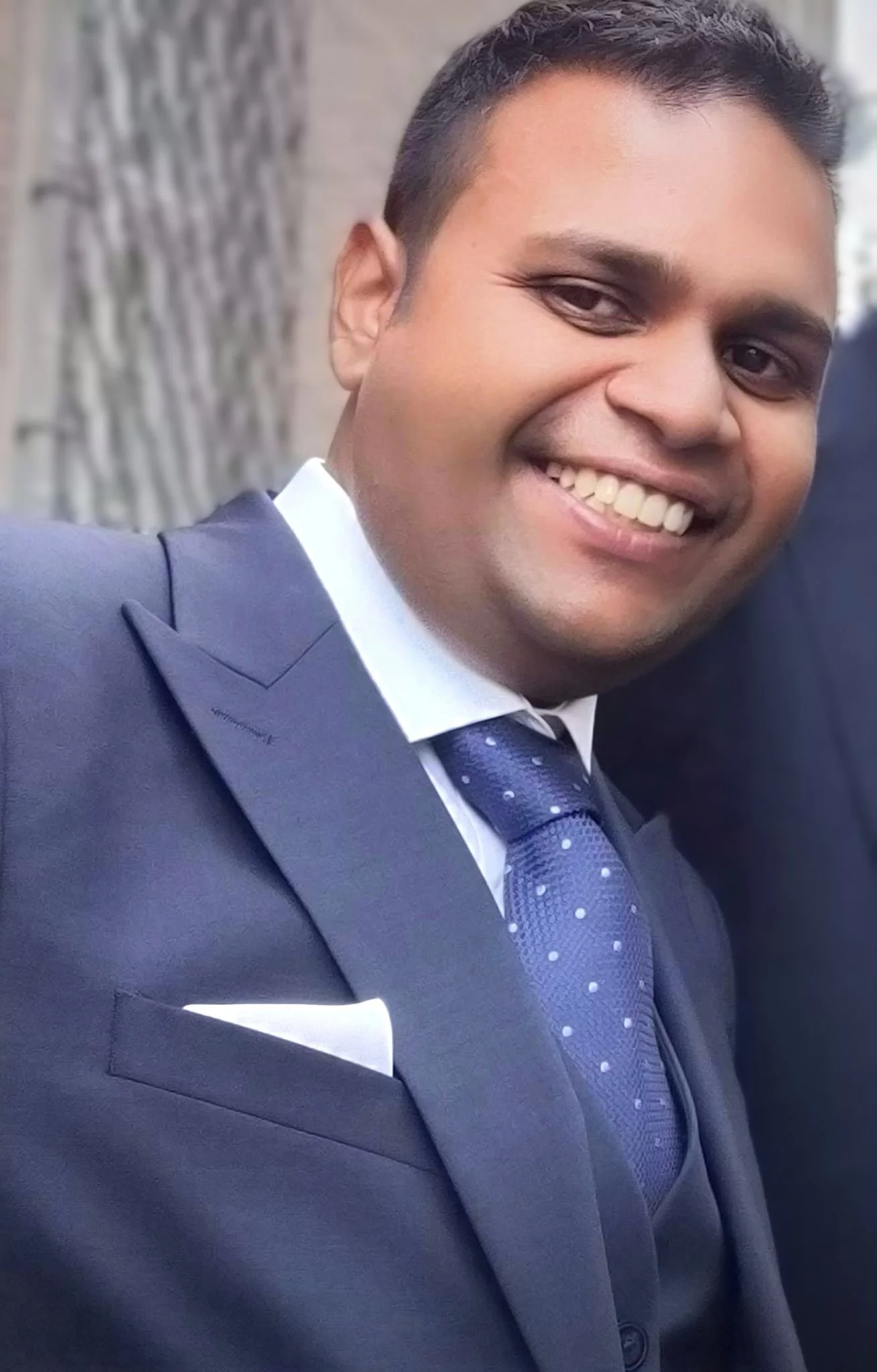 Smiling person in suit and tie with pocket square