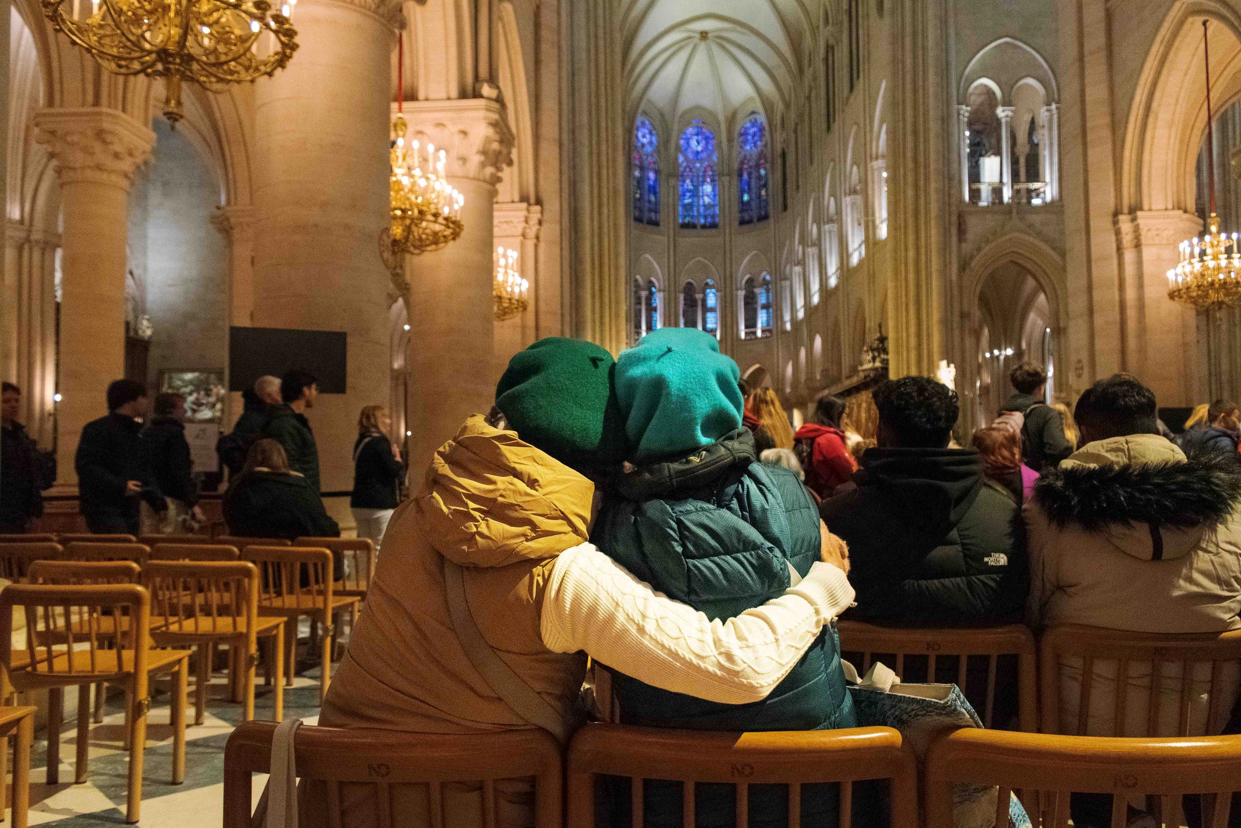 Narrow alleyway between two brick buildings with windows, utility meters, and wires, leading to a garage door at the end, in black and white.