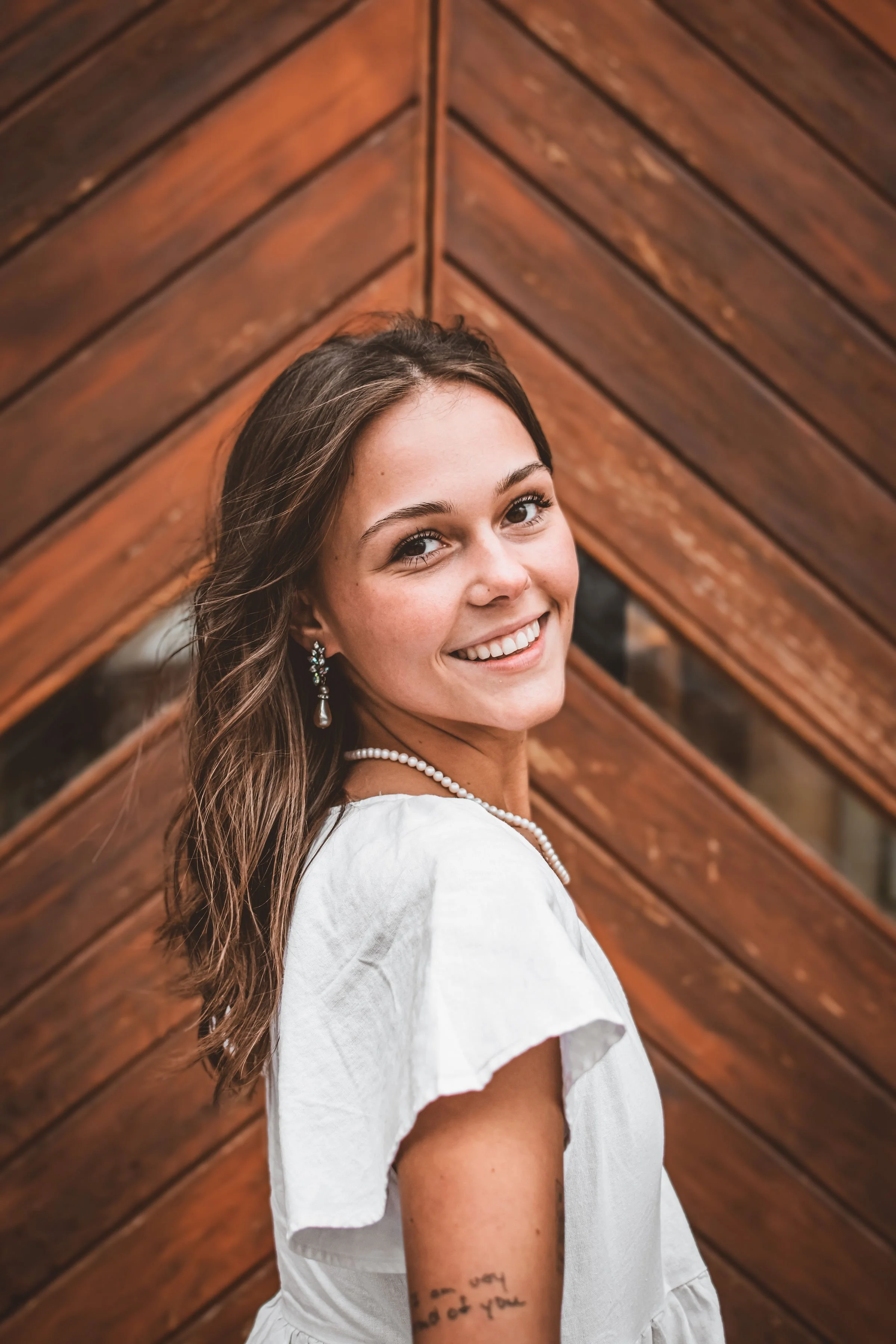 Young woman smiling in front of wooden doors