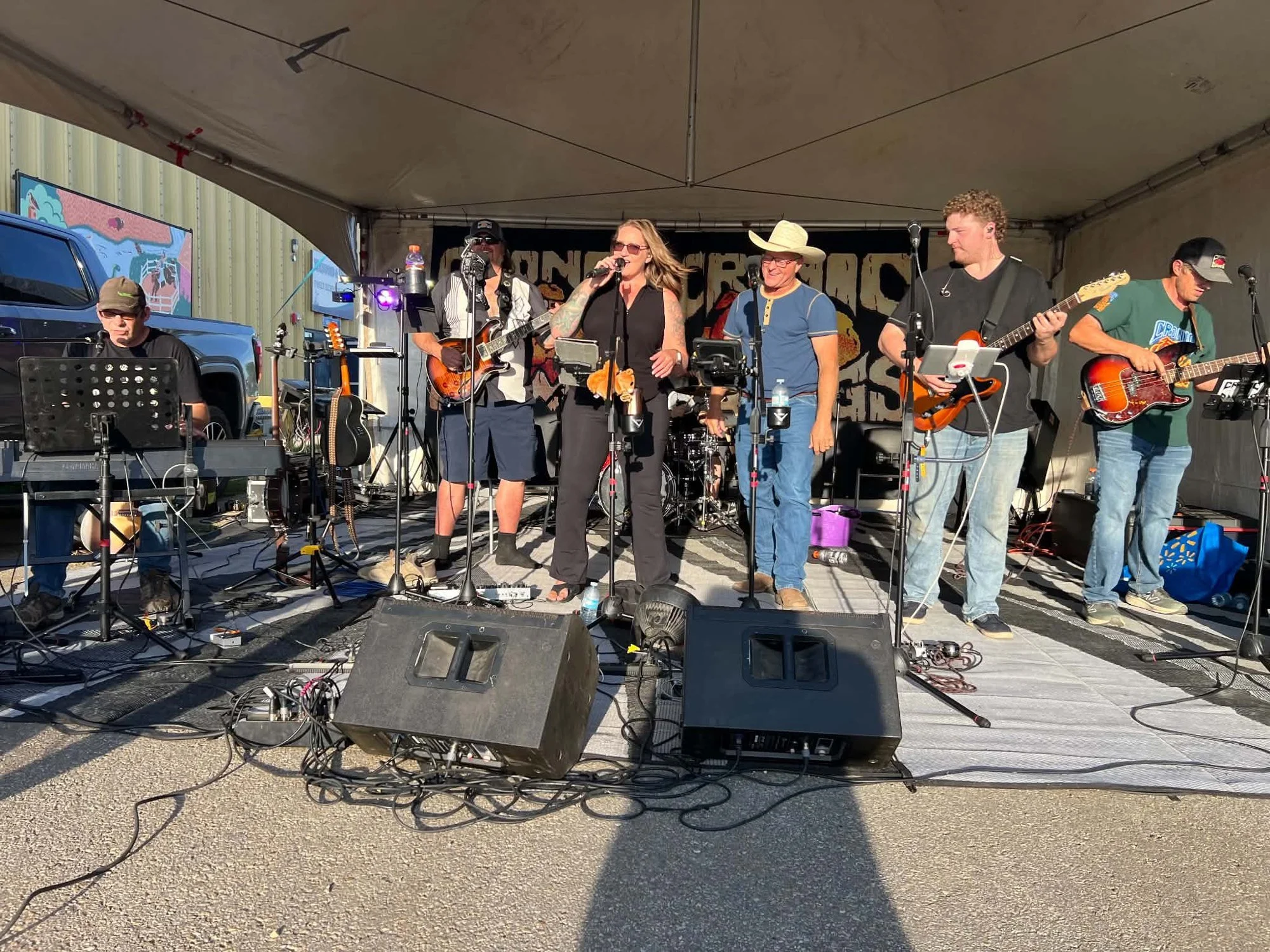 Cronic Dawgs performing live on an outdoor tent stage at a summer street party in Alberta