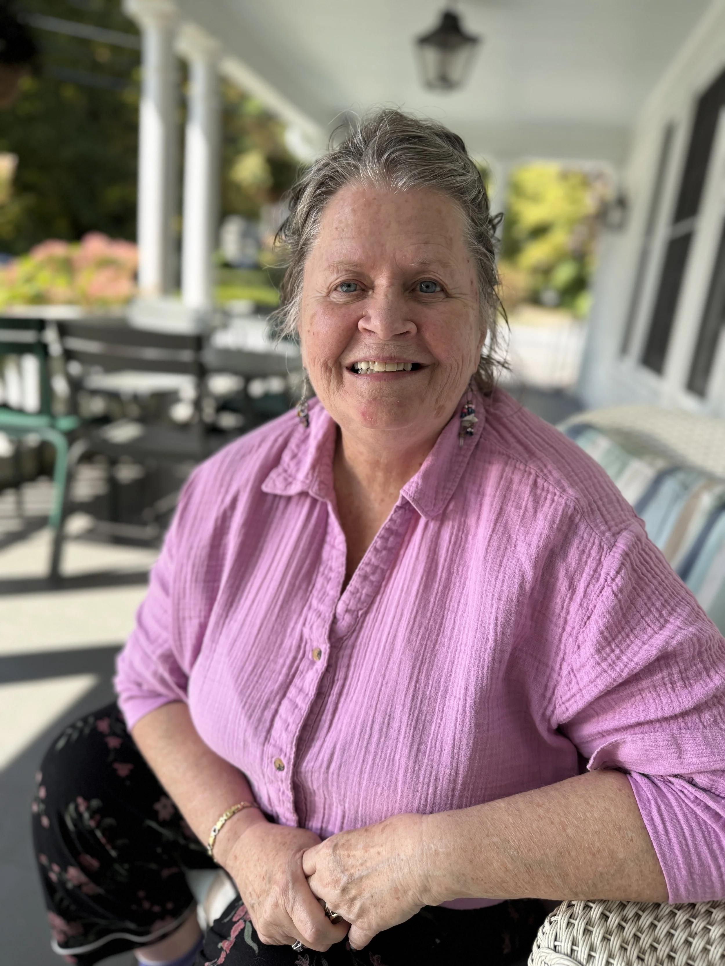 Smiling woman on porch is a Chore Service client