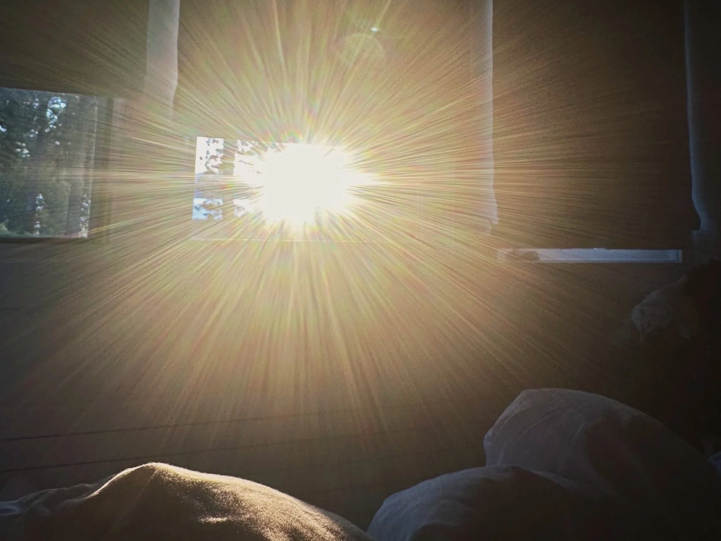 Morning sunlight bursting through a window into a quiet room