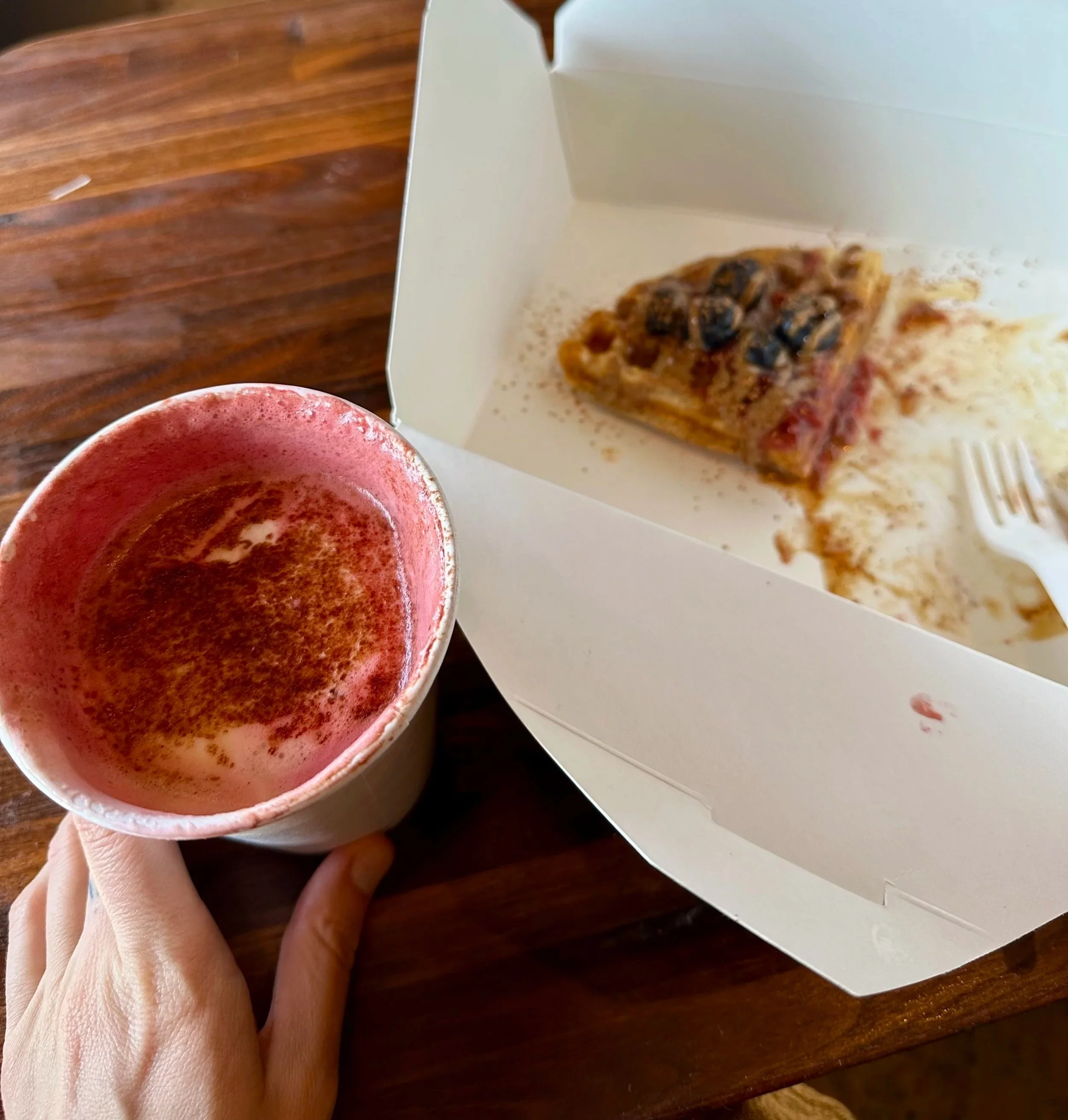 Gluten-free waffle topped with fresh fruit and nut butter alongside a rose cacao beet latte at a cozy café in Sedona, Arizona.
