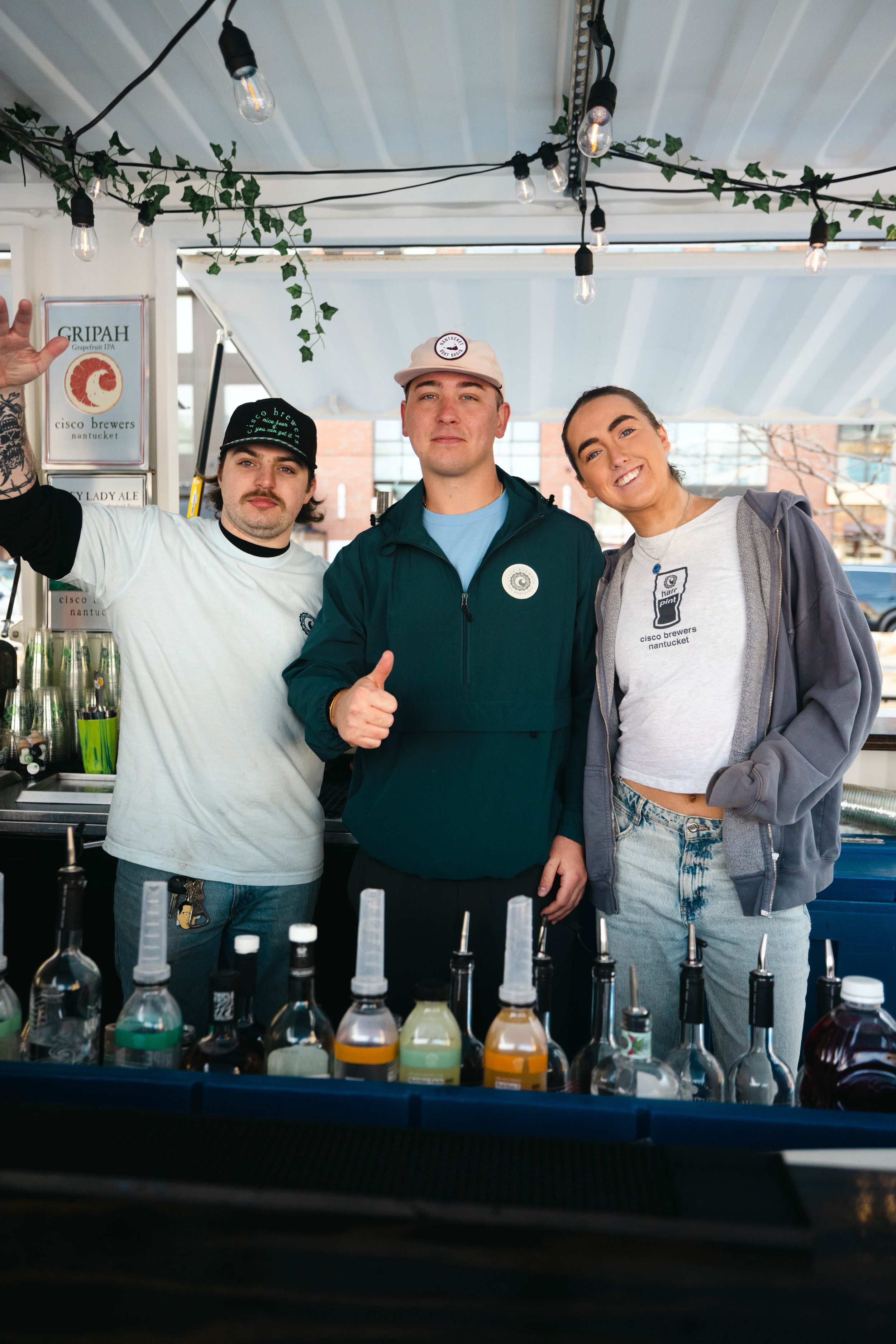 Cisco Brewers Fenway team smiling behind the bar in Boston