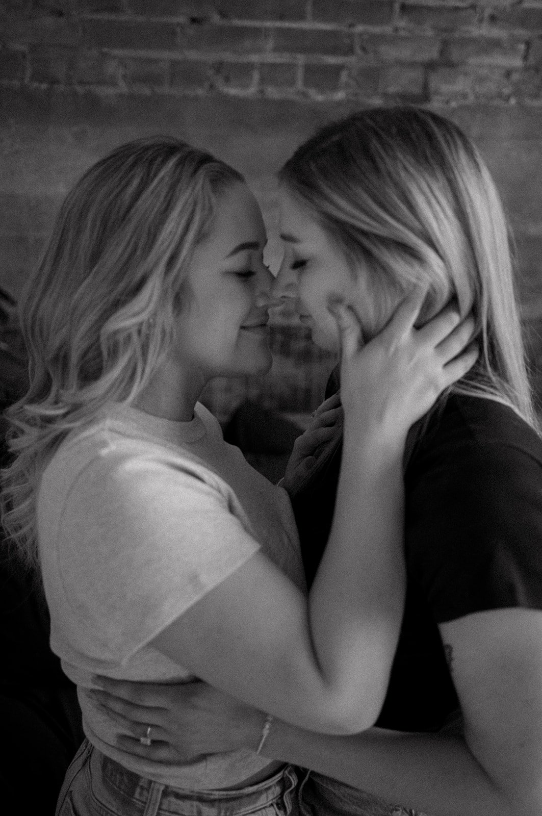 Two people embracing intimately with noses touching, black and white photo.