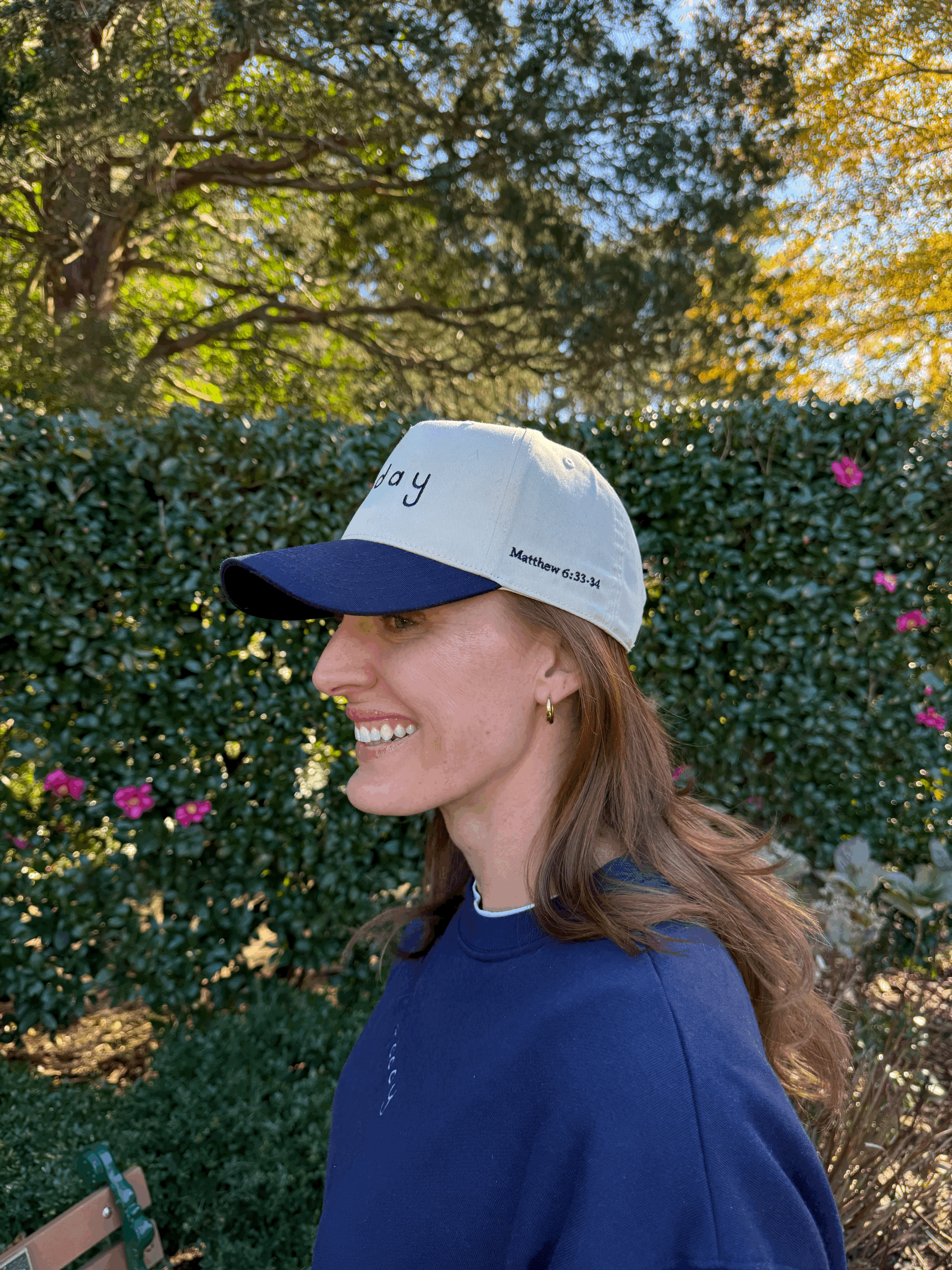 red-hair-woman-smiling- wearing-navy-five-panel-hat