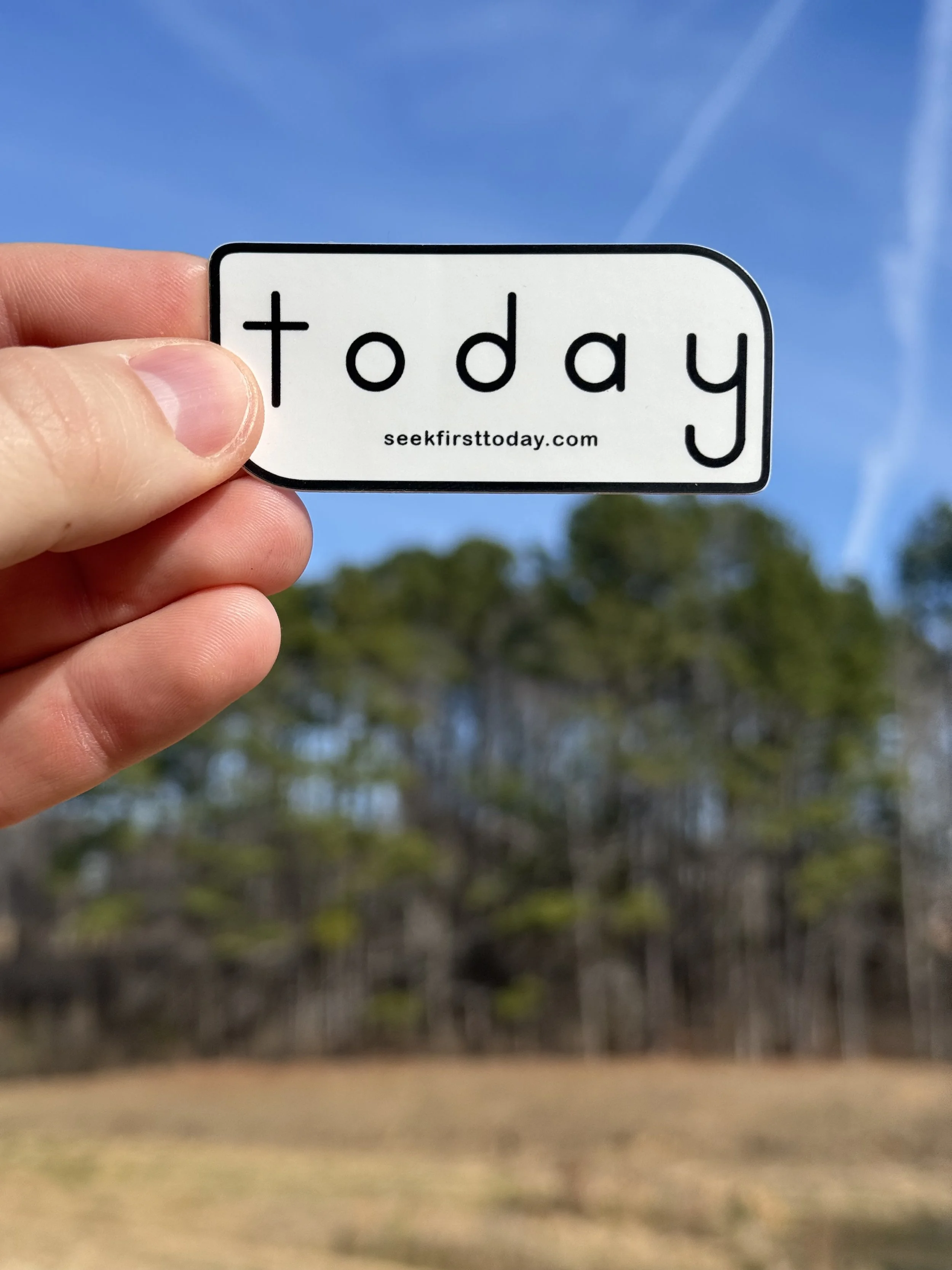 white-and-black-seek-first-today-sticker-with-trees-and-blue-sky-in-background