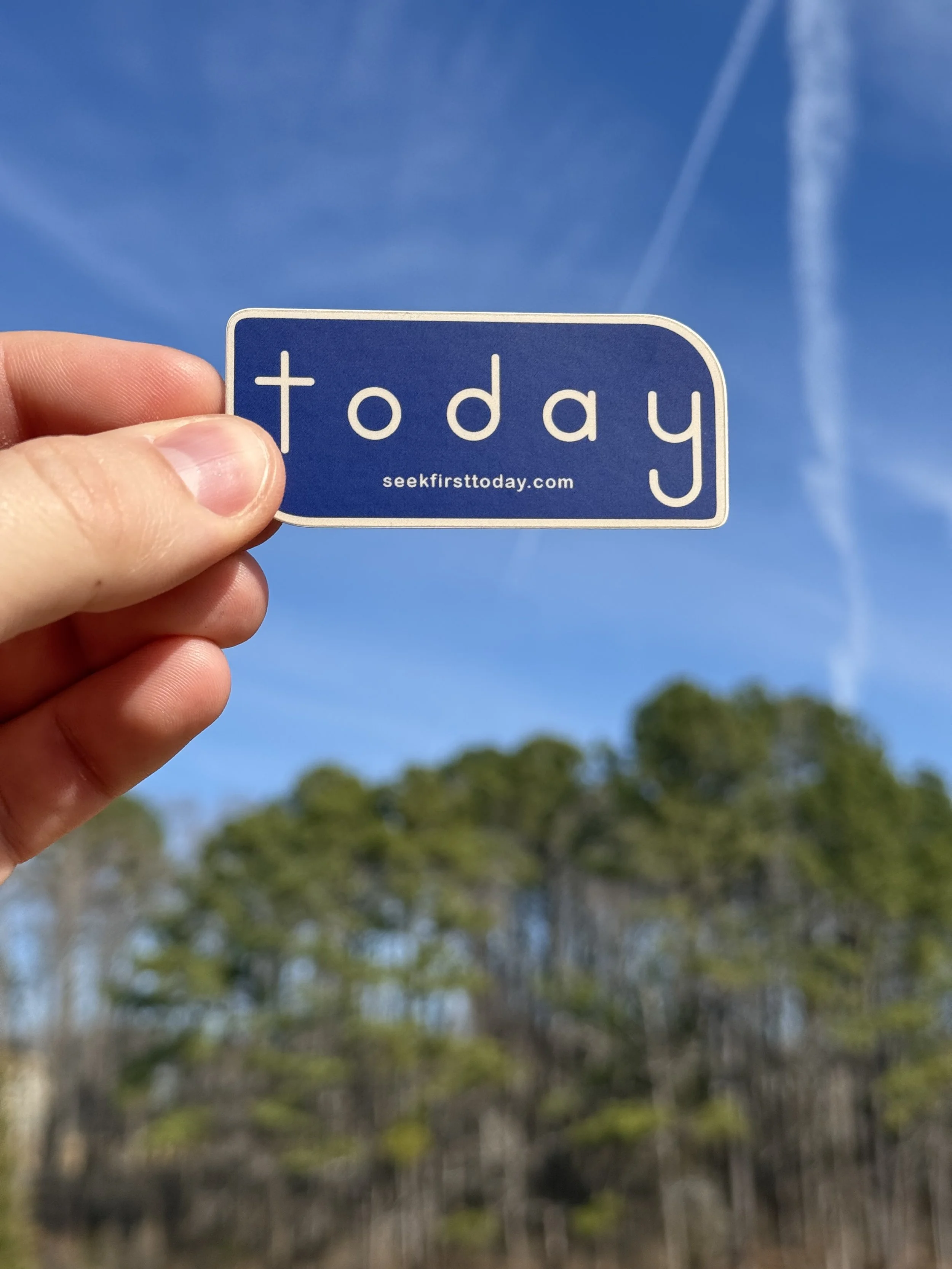 navy-and-sand-seek-first-today-sticker-with-trees-and-blue-sky-in-background