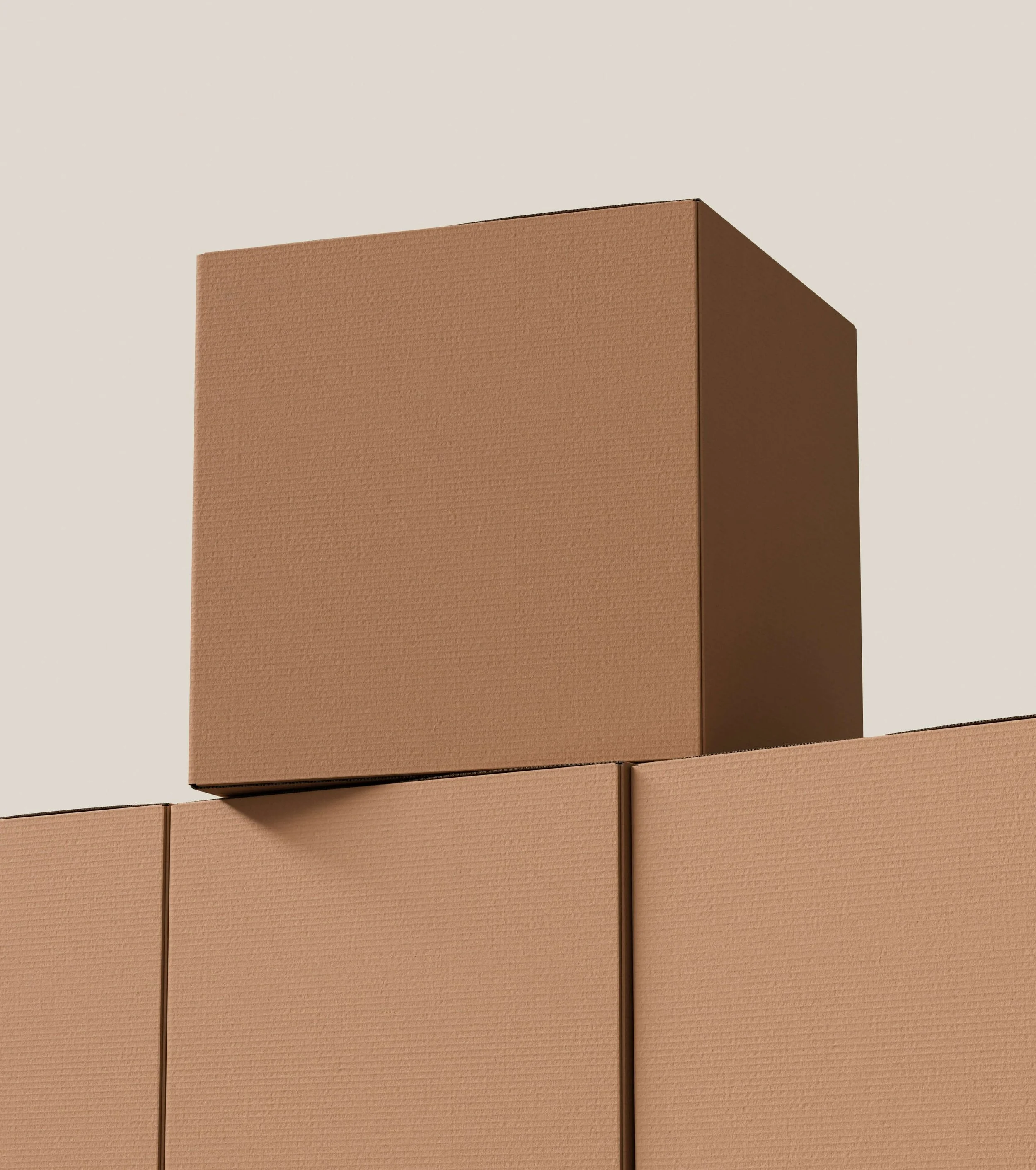 Stack of brown cardboard moving boxes against a neutral background.