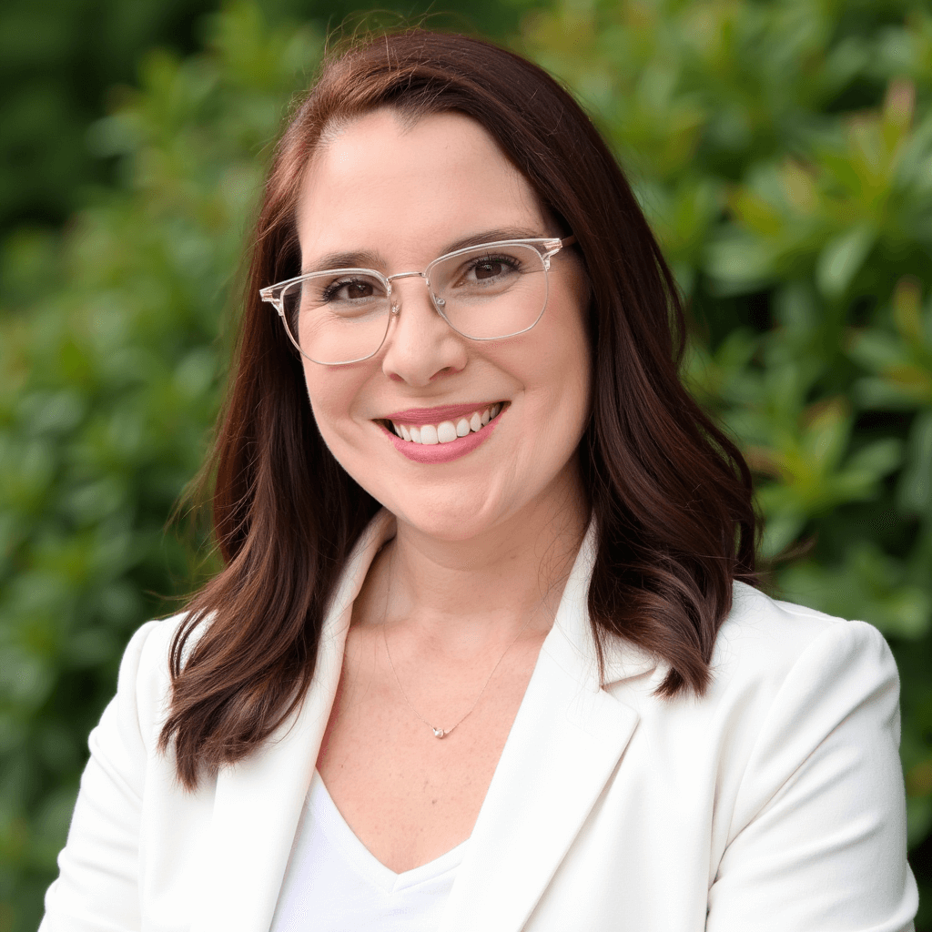 Rannie Tanner Headshot standing in front of a green bush.