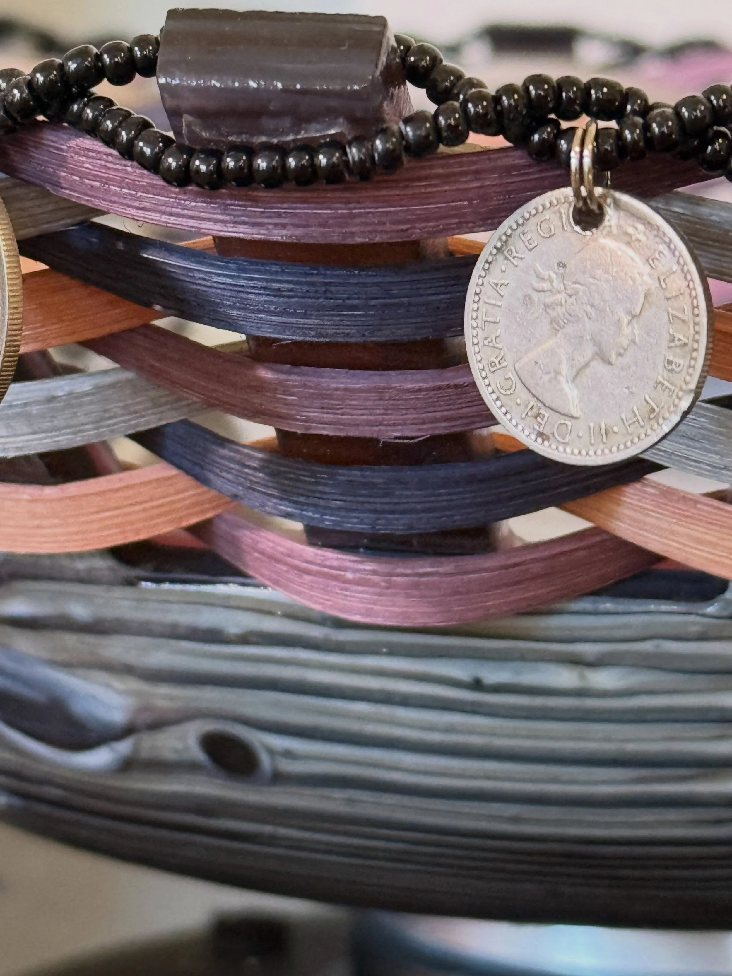 A closer look at Candace Pratt&rsquo;s work reveals an unexpected meeting of materials.

A glass vessel forms the structure, while fiber is woven around and through it, joined by beadwork and suspended coins. The combination of hard glass and softer 