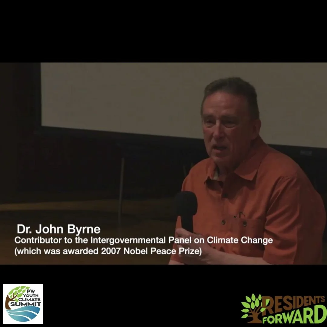 A man speaking into a microphone at an event, with text identifying him as Dr. John Byrne, a contributor to the Intergovernmental Panel on Climate Change. Logos for the PW Youth Climate Summit and Residents Forward are visible.