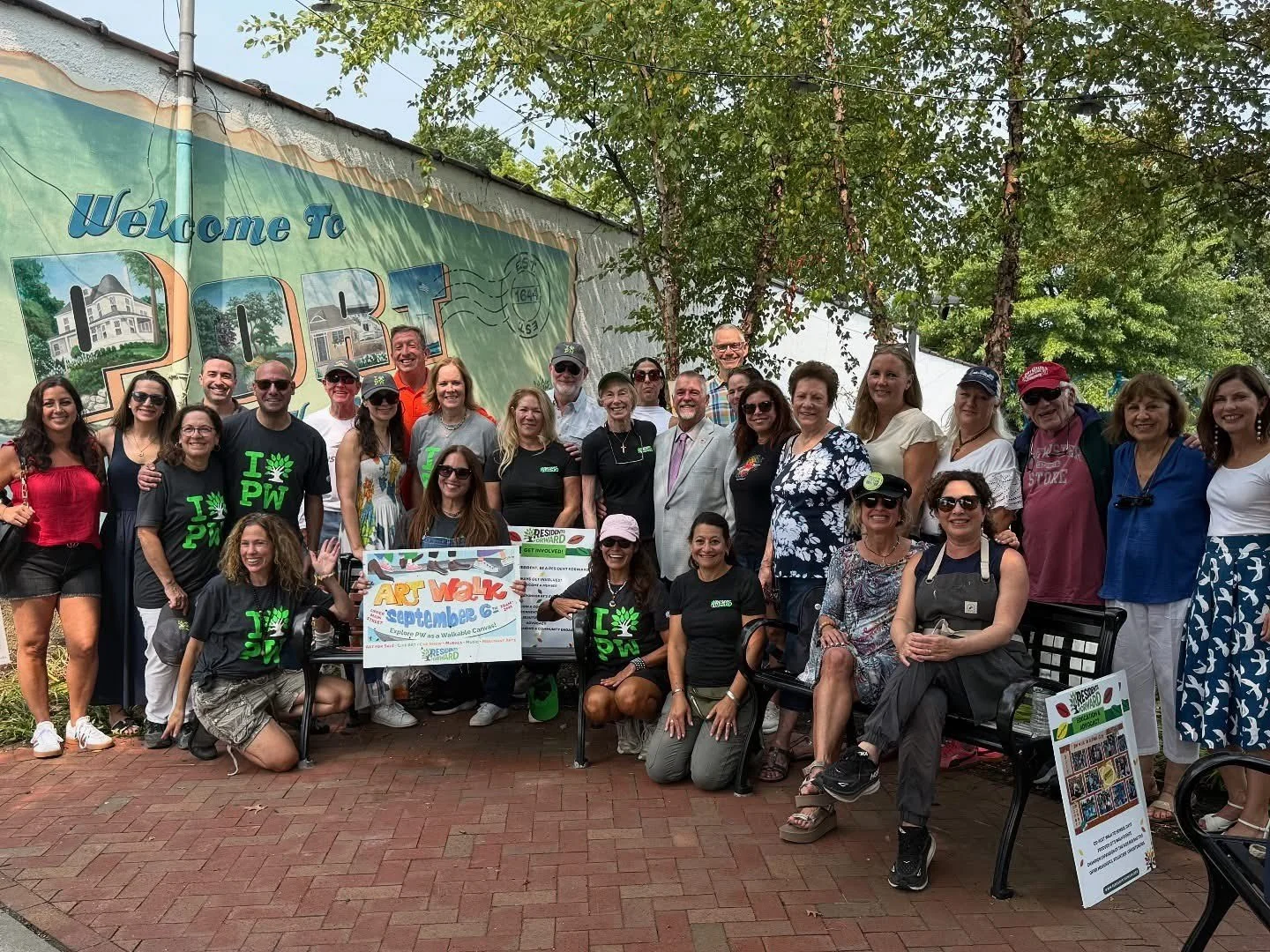 A group of people posing for a photo outdoors in front of a 