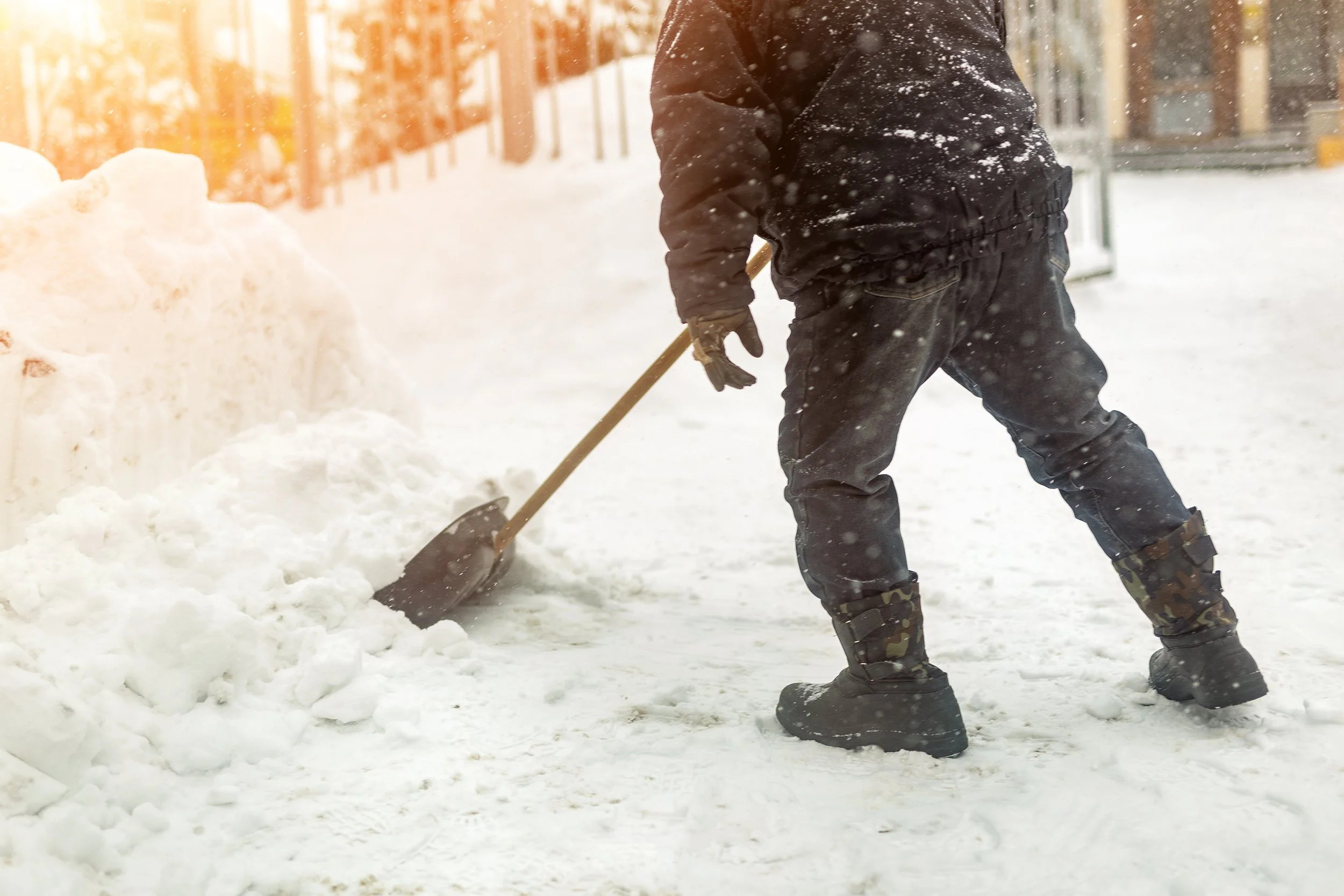 Action Construction Employee Shoveling Snow