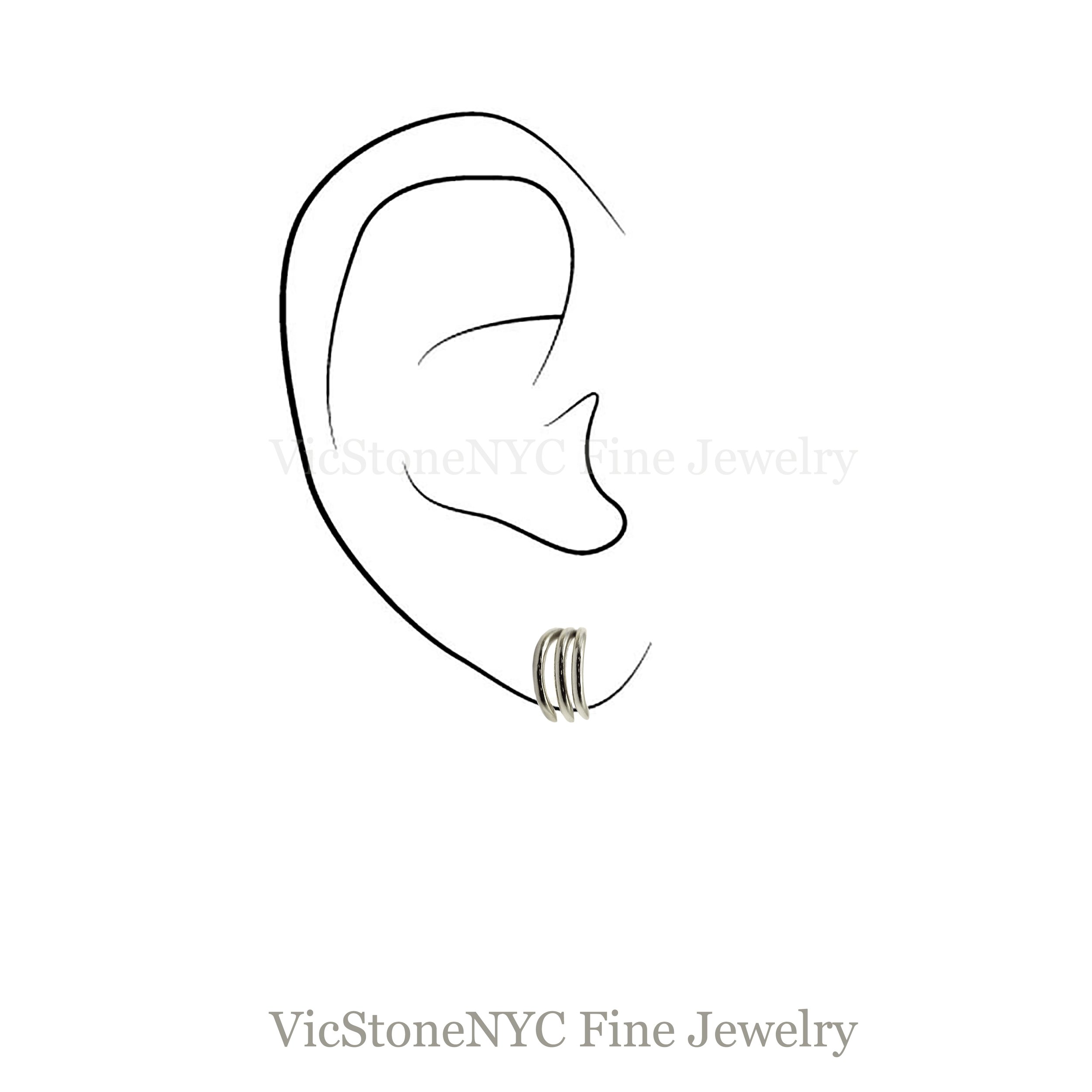 Side profile of 14K yellow gold huggie earrings with triple line detail on earlobe
