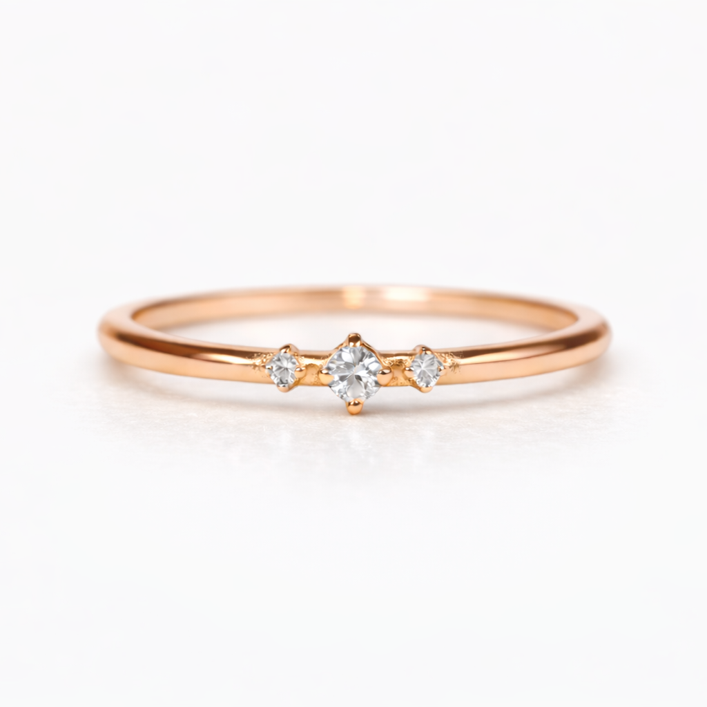 14K rose gold trio diamond ring on finger, dainty minimalist stacking ring with three clear sparkling diamonds, elegant everyday fine jewelry by VicStoneNYC