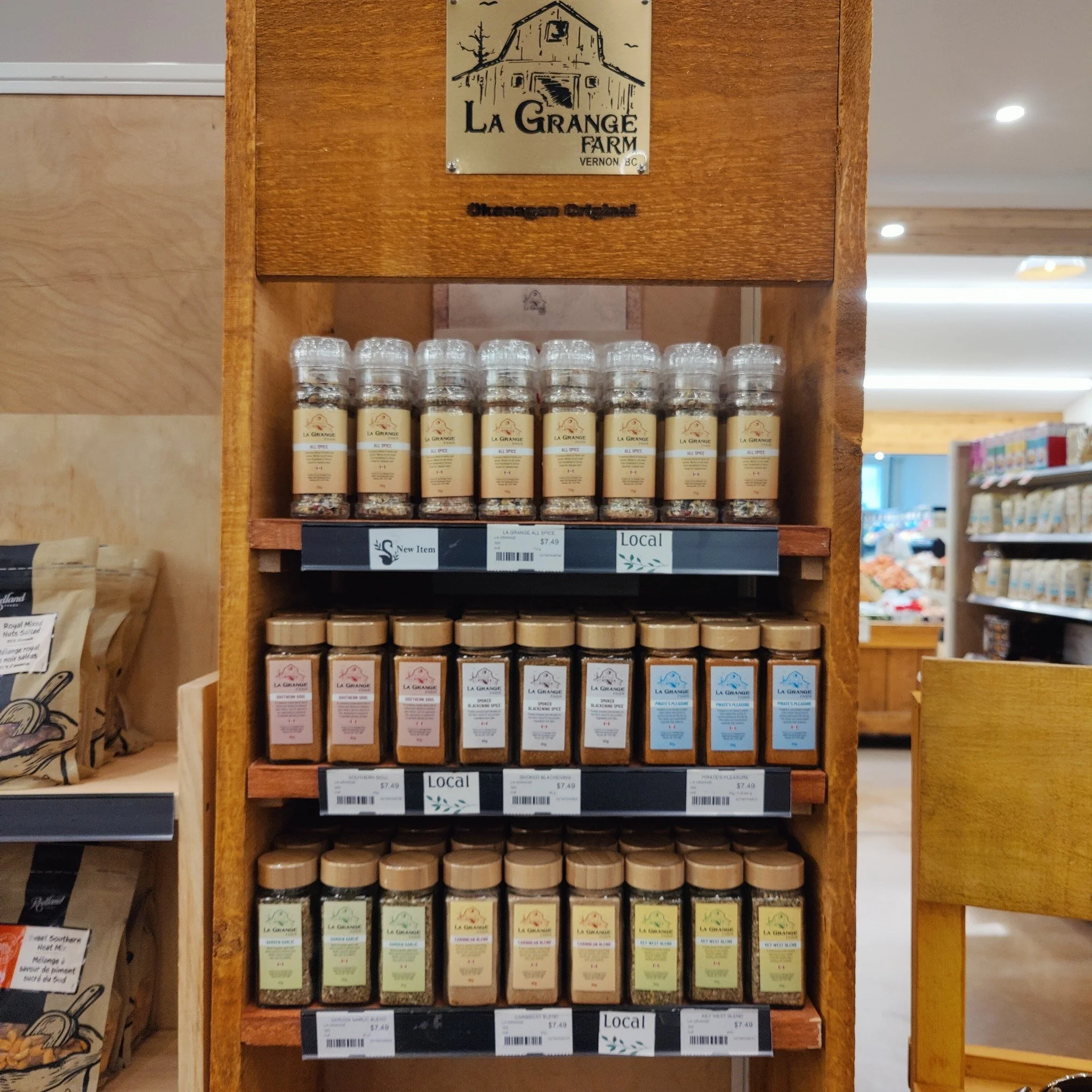 Shelf display of La Grange Farm spice bottles in a store.