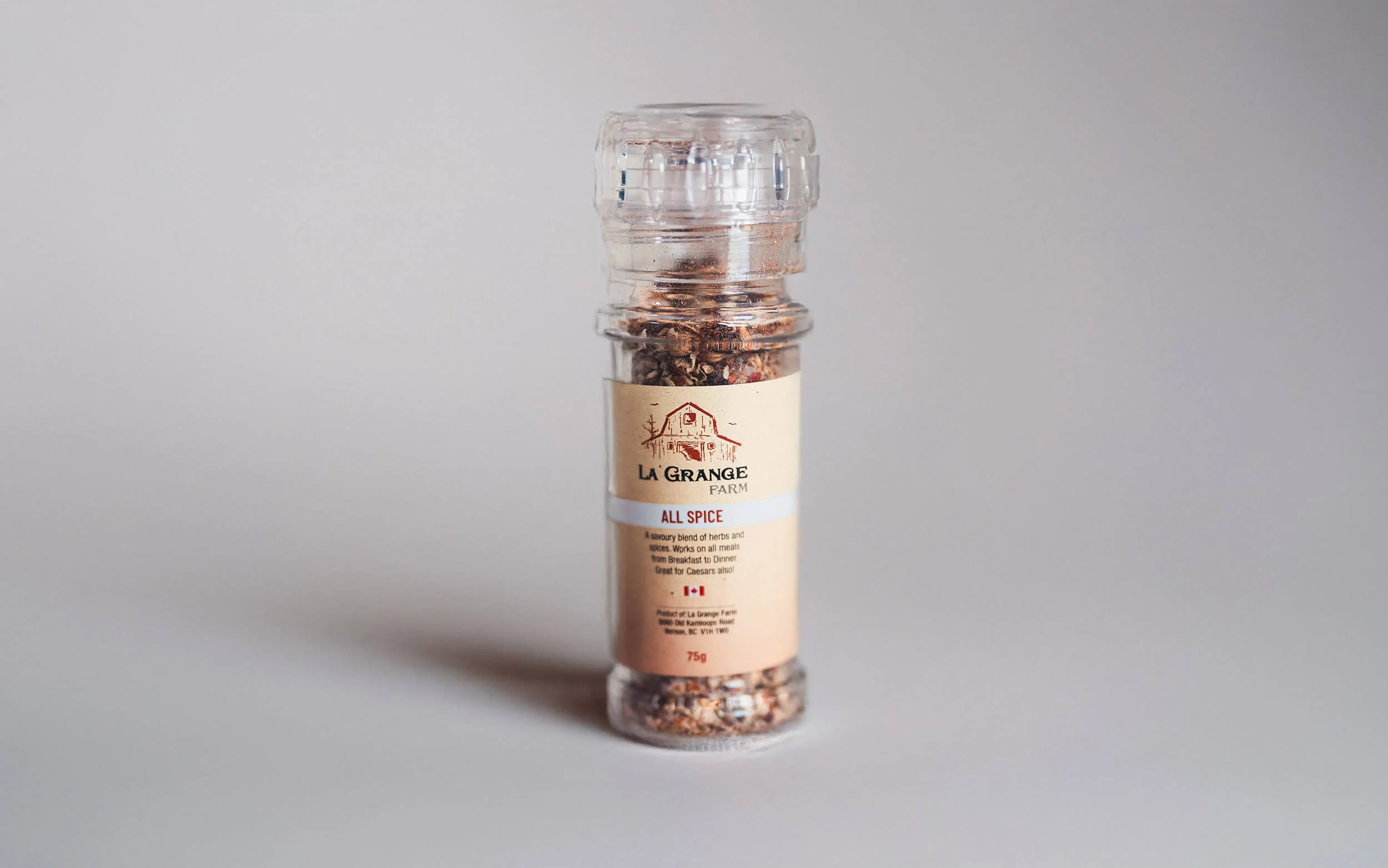 Bottle of La Grange Farm all spice seasoning on a neutral background.
