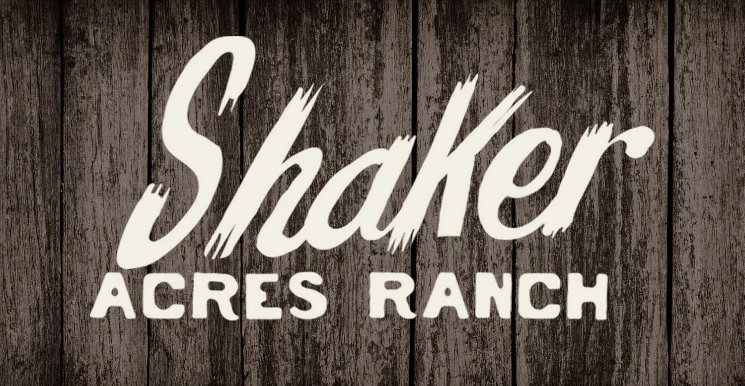 "Shaker Acres Ranch" sign with rustic wooden background.