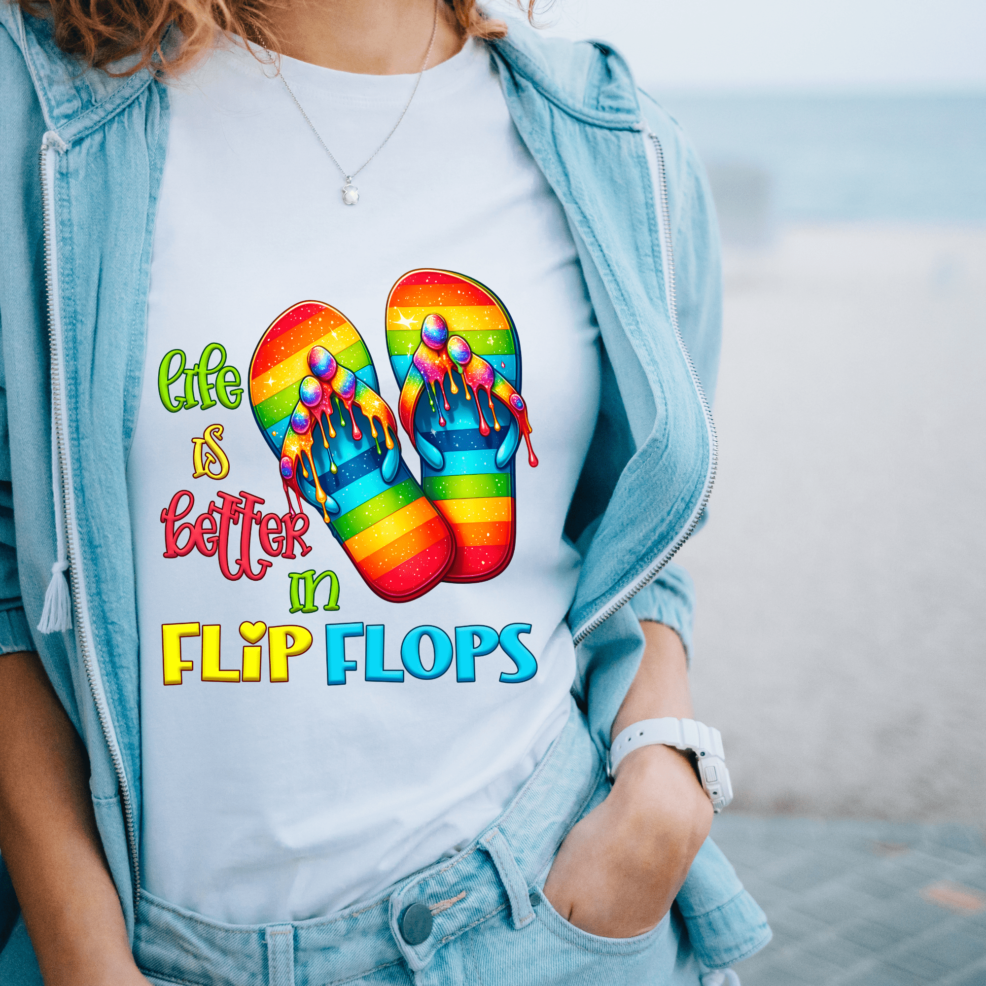 Woman wearing a white T-shirt with a colorful design of rainbow flip flops and the text "Life is better in Flip Flops".