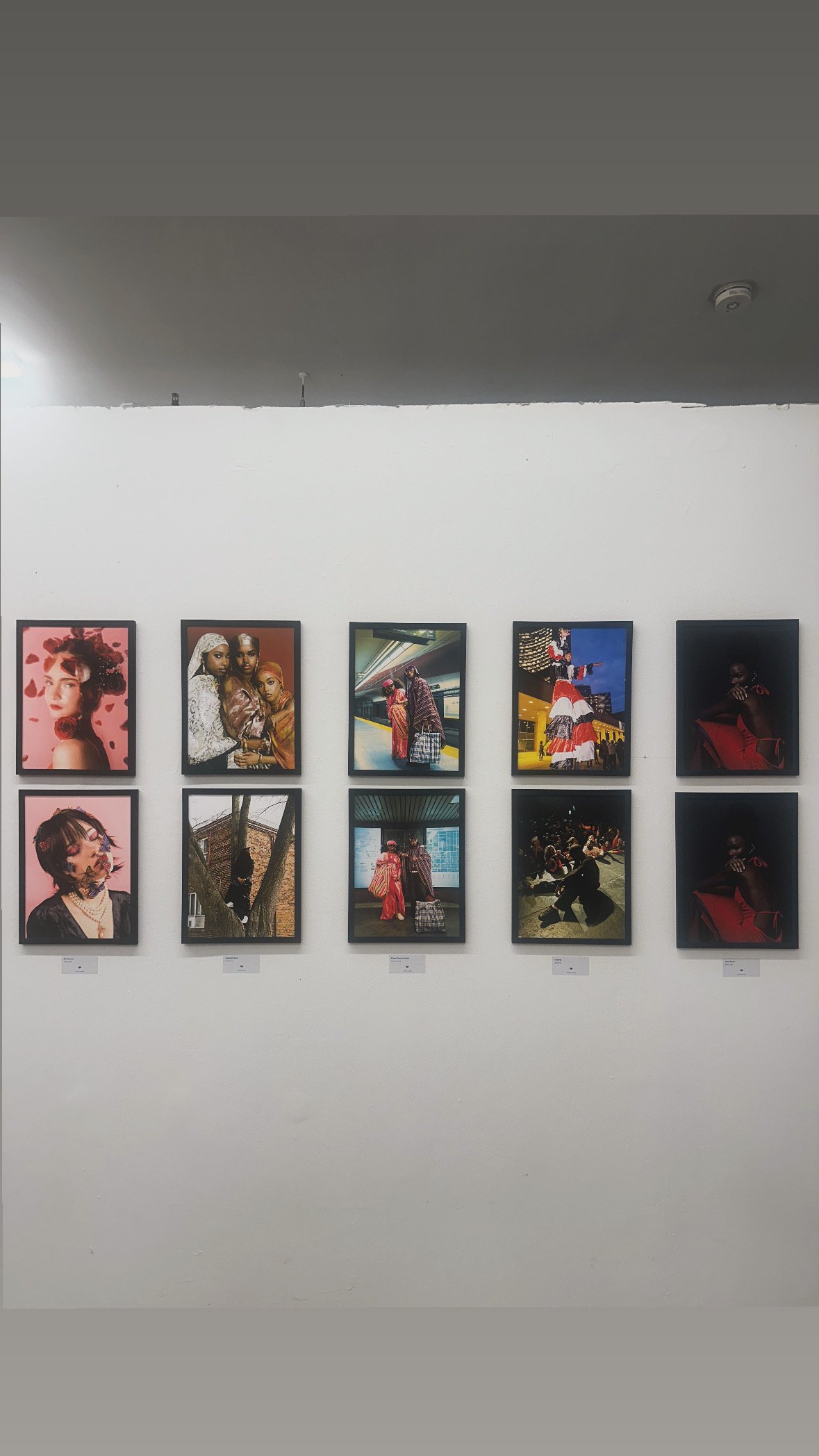 Framed photographs arranged on a gallery wall at the Capturing Toronto photo exhibition.