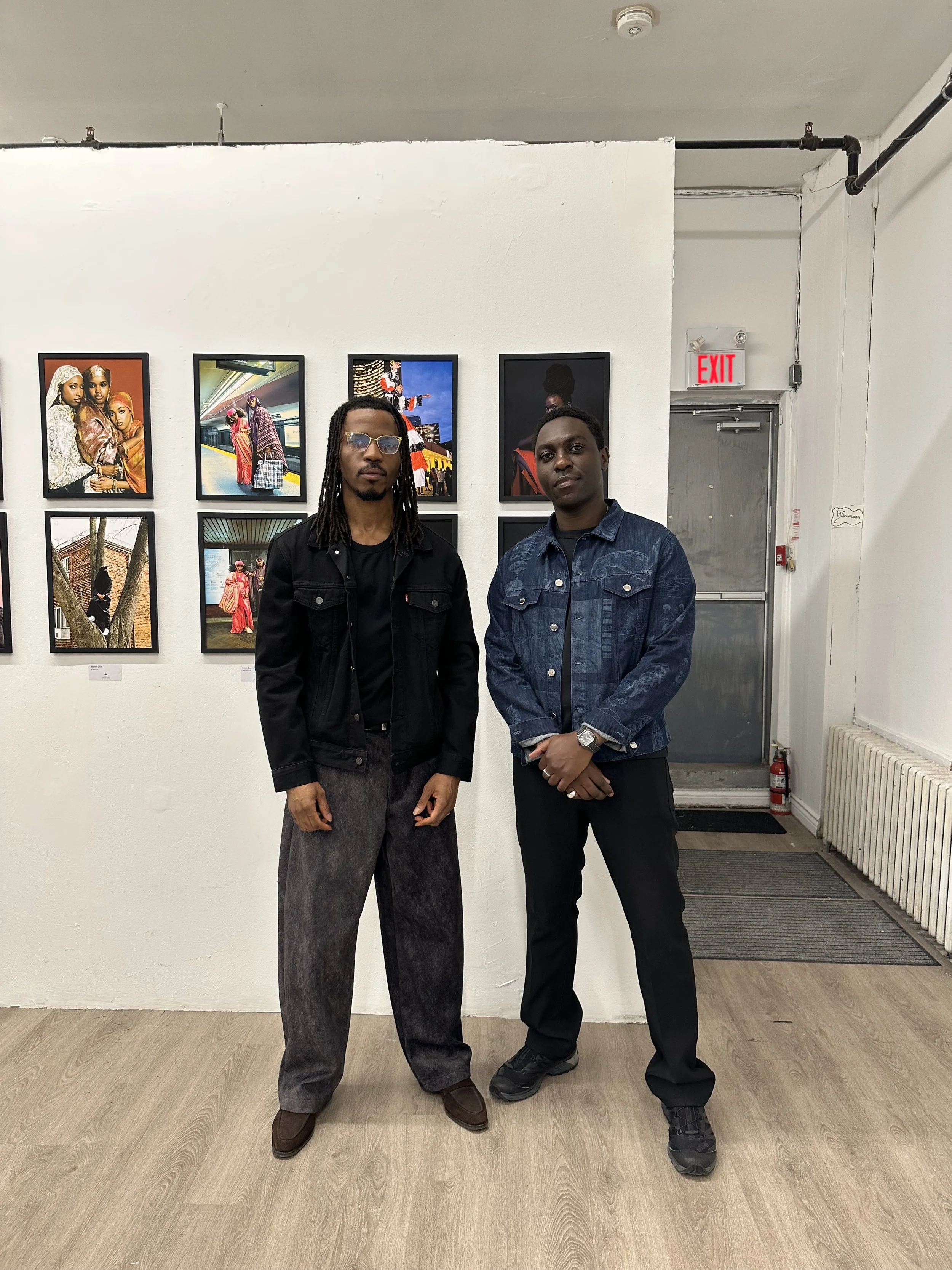 Two guests standing by a wall of photographs at the Capturing Toronto photo exhibition.