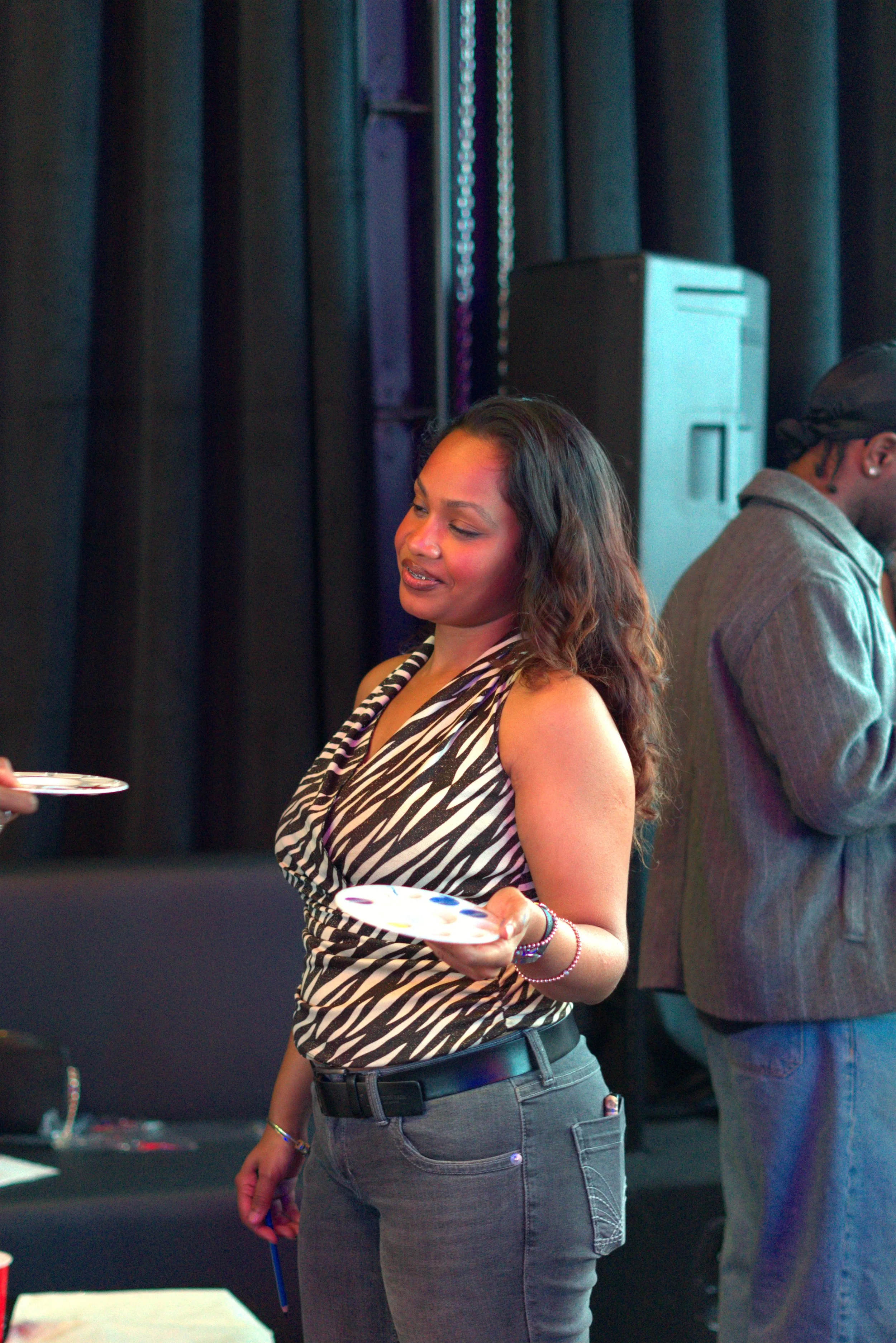 A guest holding a plate at a Toronto paint and sip night.