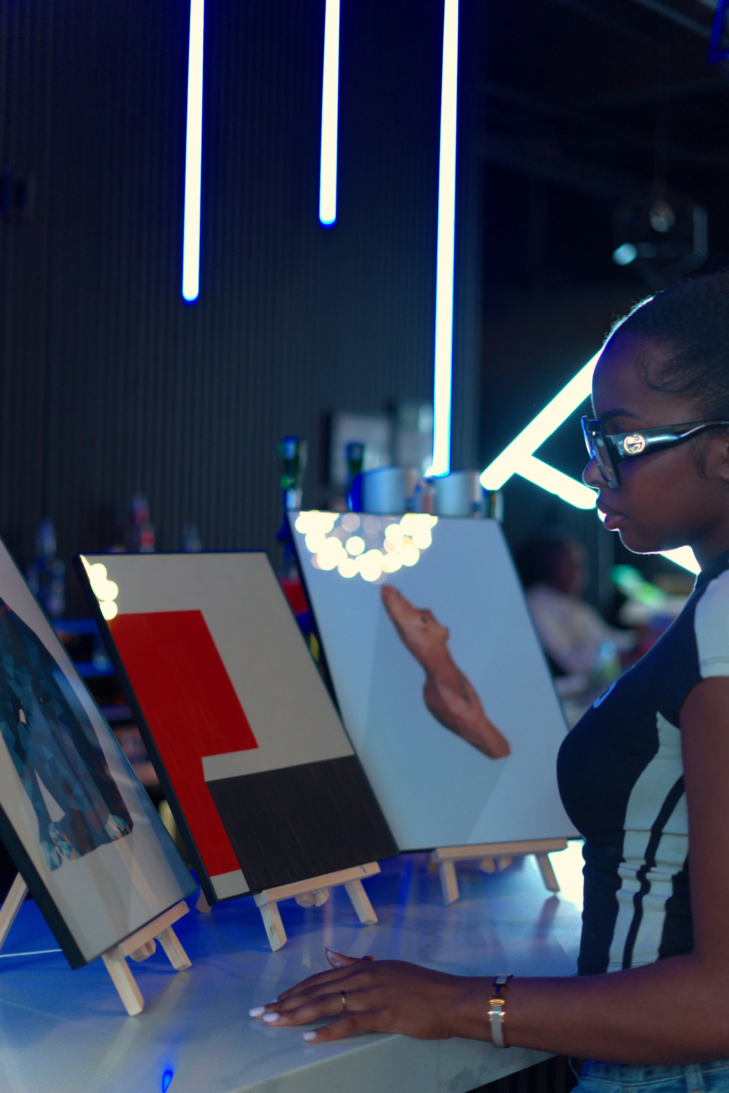 Guest viewing finished paintings on a table at a Toronto paint and sip night.