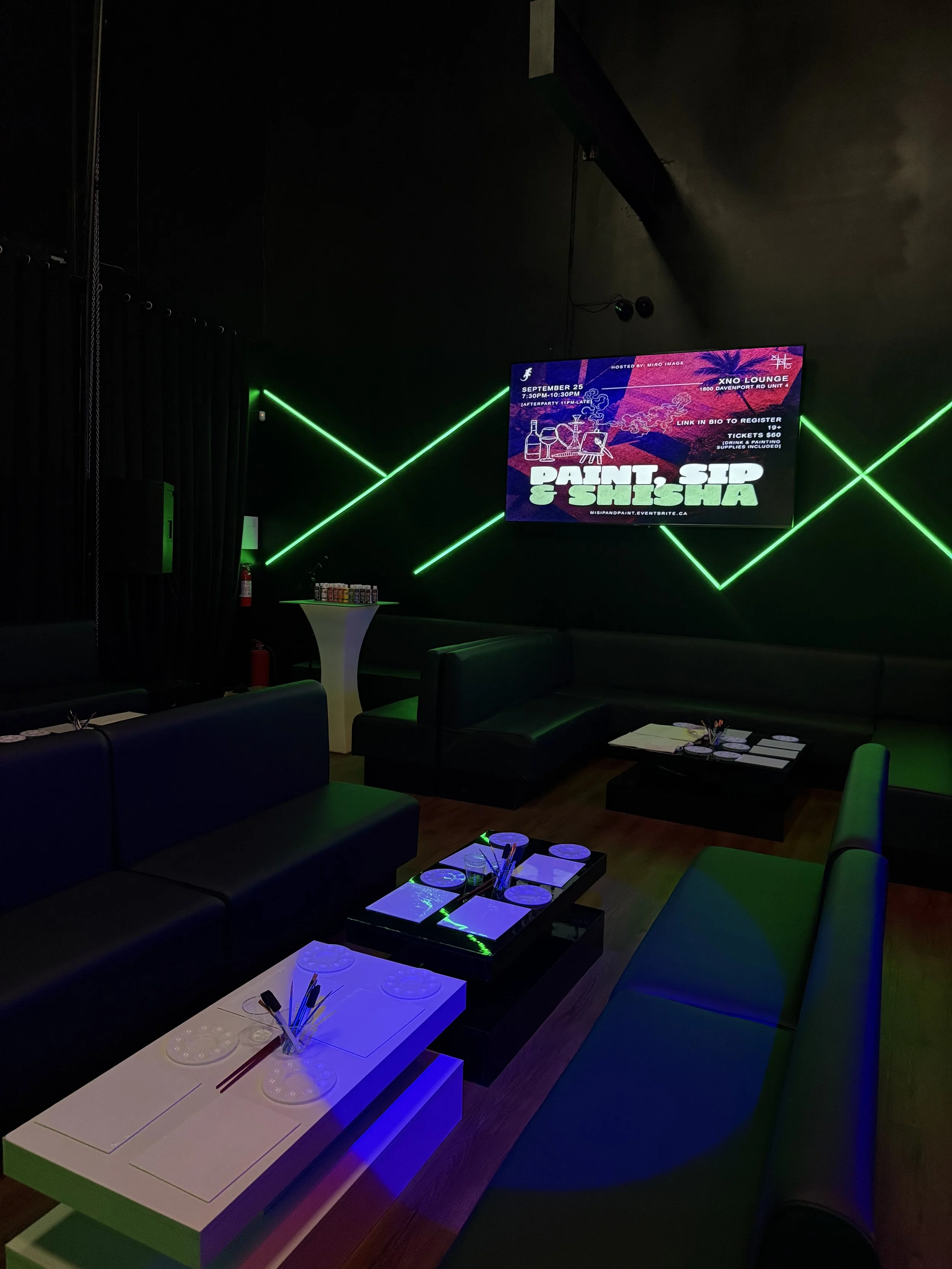Neon lights glowing in the venue at a Toronto paint and sip night.