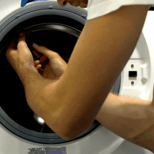 Persona ajustando una pieza en el interior de una lavadora