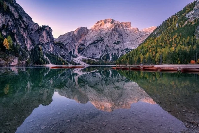 LAGO DI BRAIES / PRAGSER WILDSEE

Things I loved about this place:
✅ The pristine reflections in the emerald water
✅ The first glow on the peaks
✅ The pop of autumn colour in the surrounding forest
✅ The cute boatshed and boats out on the water addin