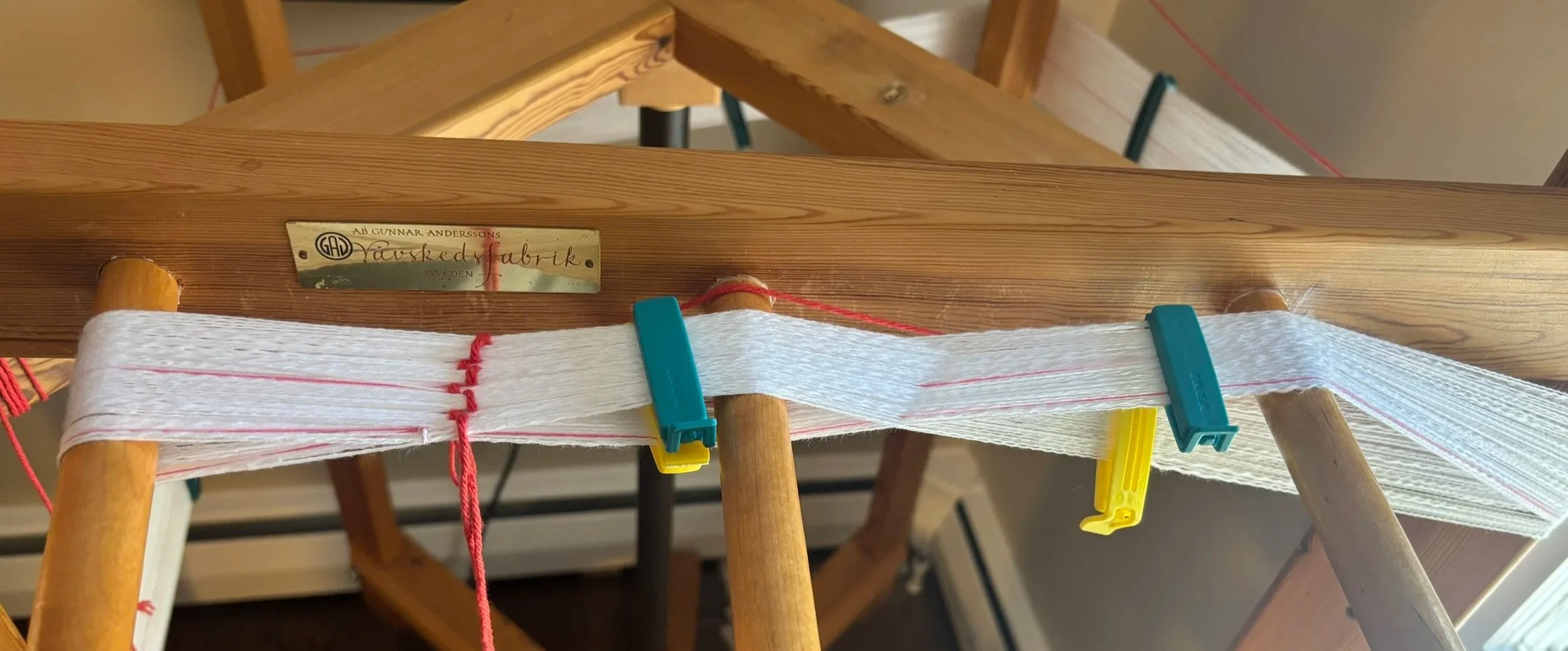 Yarn on a warping mill with a counting string and secured with chip clips