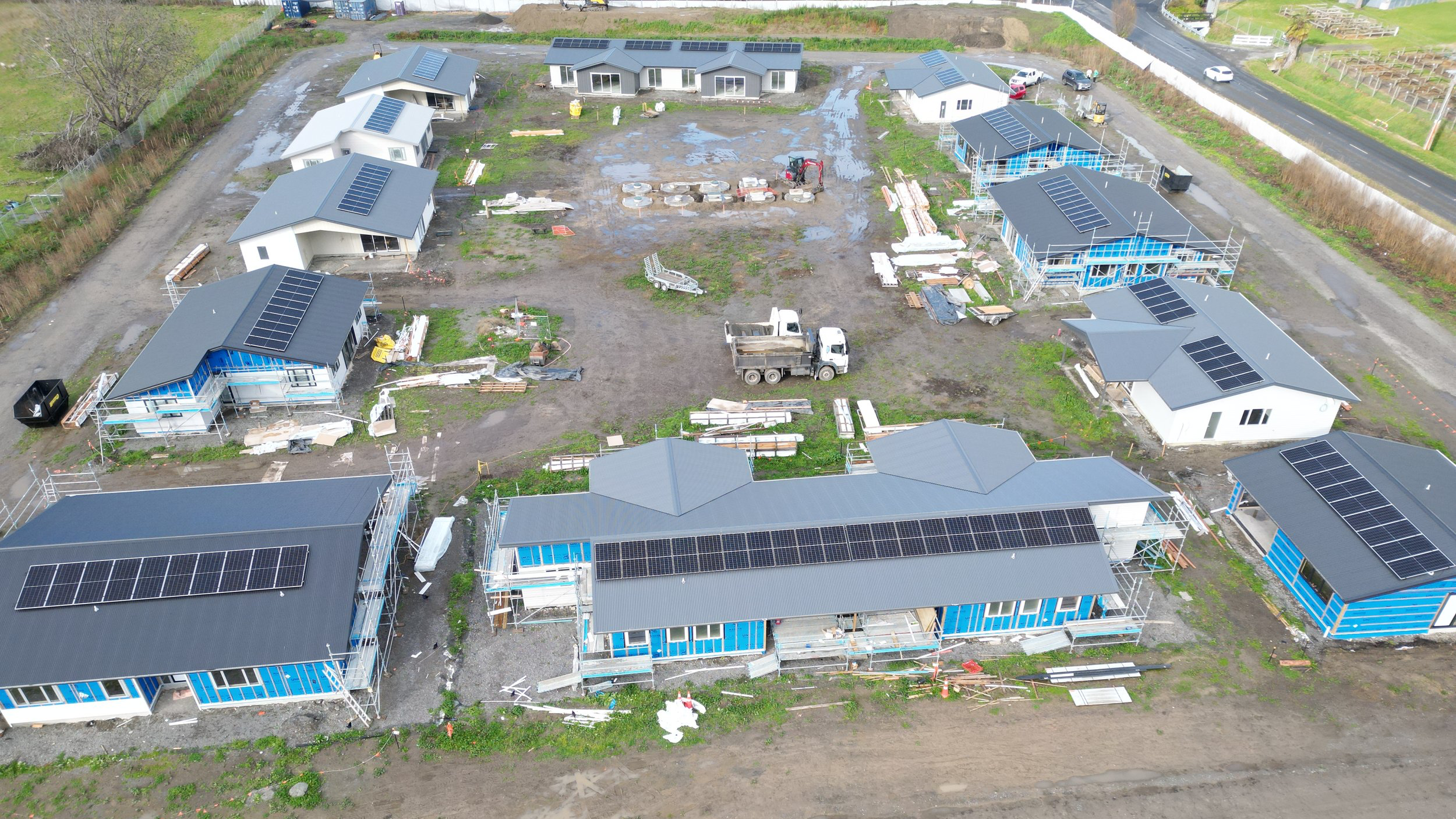 An aerial view of the Whenuakura Whānau Trust housing development in progress — a vision of whānau-led housing taking shape. Each whare is fitted with rooftop solar panels, reflecting our commitment to sustainable, future-focused living. These energy