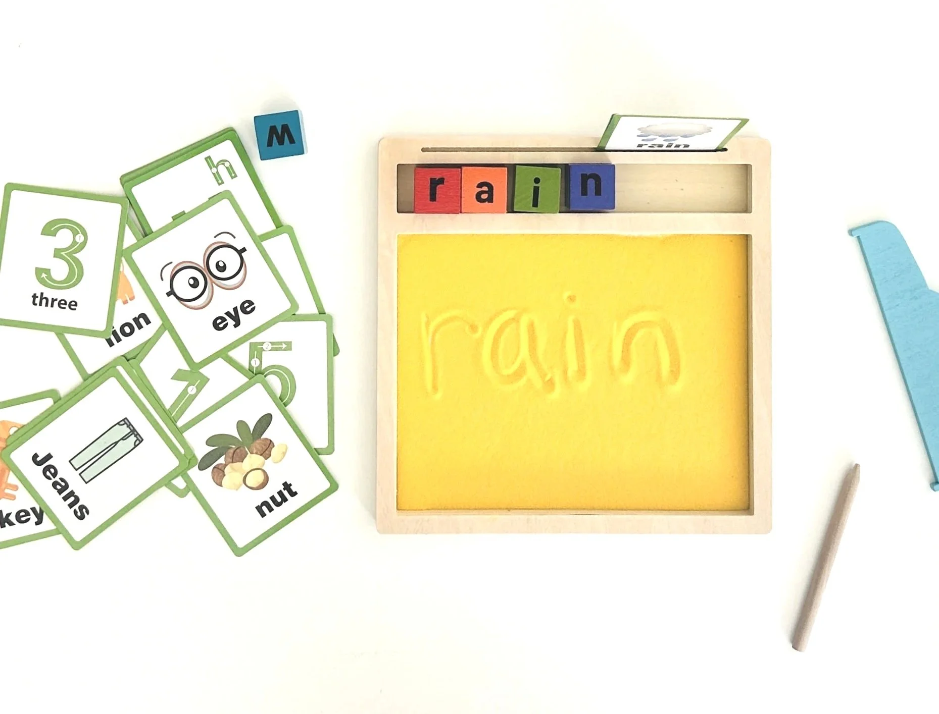 Educational tool with letter blocks spelling 'rain' and corresponding word labels like 'eye' and 'nut', along with flashcards displaying the number three and related images.