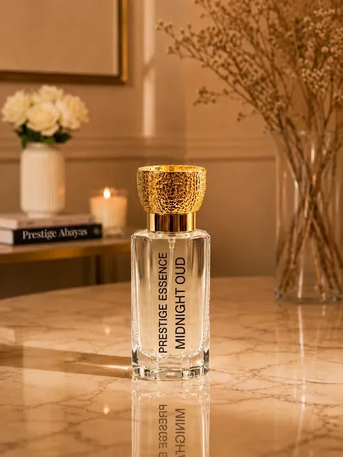 A bottle of Prestige Essence Midnight Oud perfume on a marble surface, with a bookshelf, candle, and flower vase in the background.