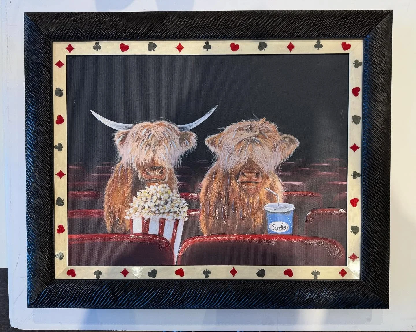 Fun framing for a game and movie room!  These cute Highland cows are enjoying a movie night, complete with snacks.  The outer frame is a from Fotiou and the inner frame is an Italian inlay from Global Arts.
#framecraftersgallery #bonaircenter #marinc