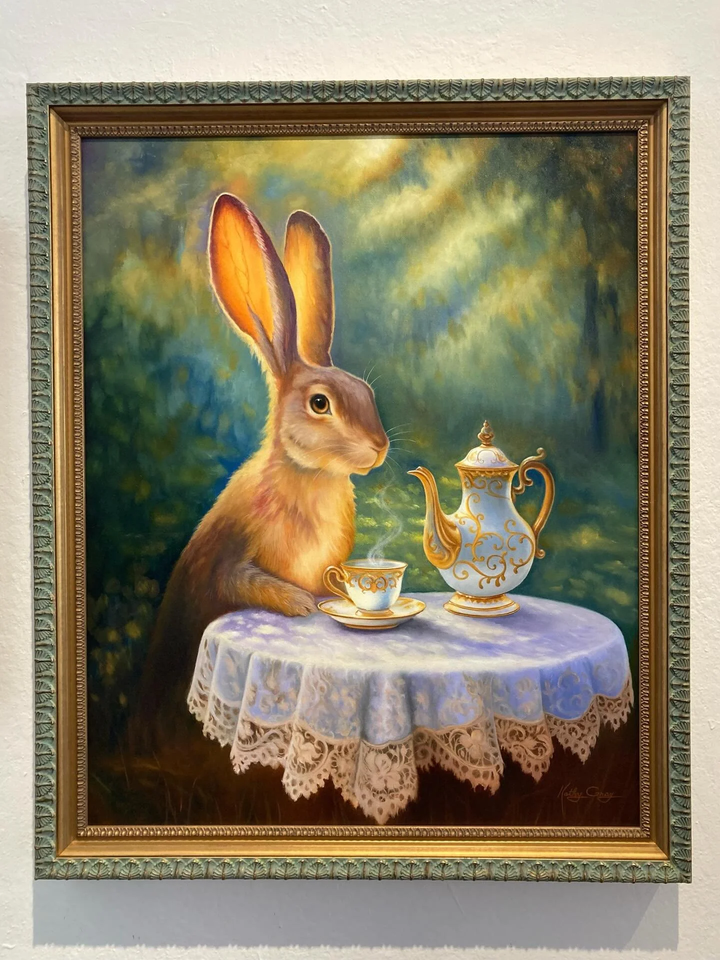Newest painting by Kathy Gray.  This beautiful bunny enjoying a cup of tea is double framed with a gold frame by Larson Juhl on the inside and surrounded by a teal Bella frame with a beautiful leaf pattern on the outside.  We liked how the pattern on