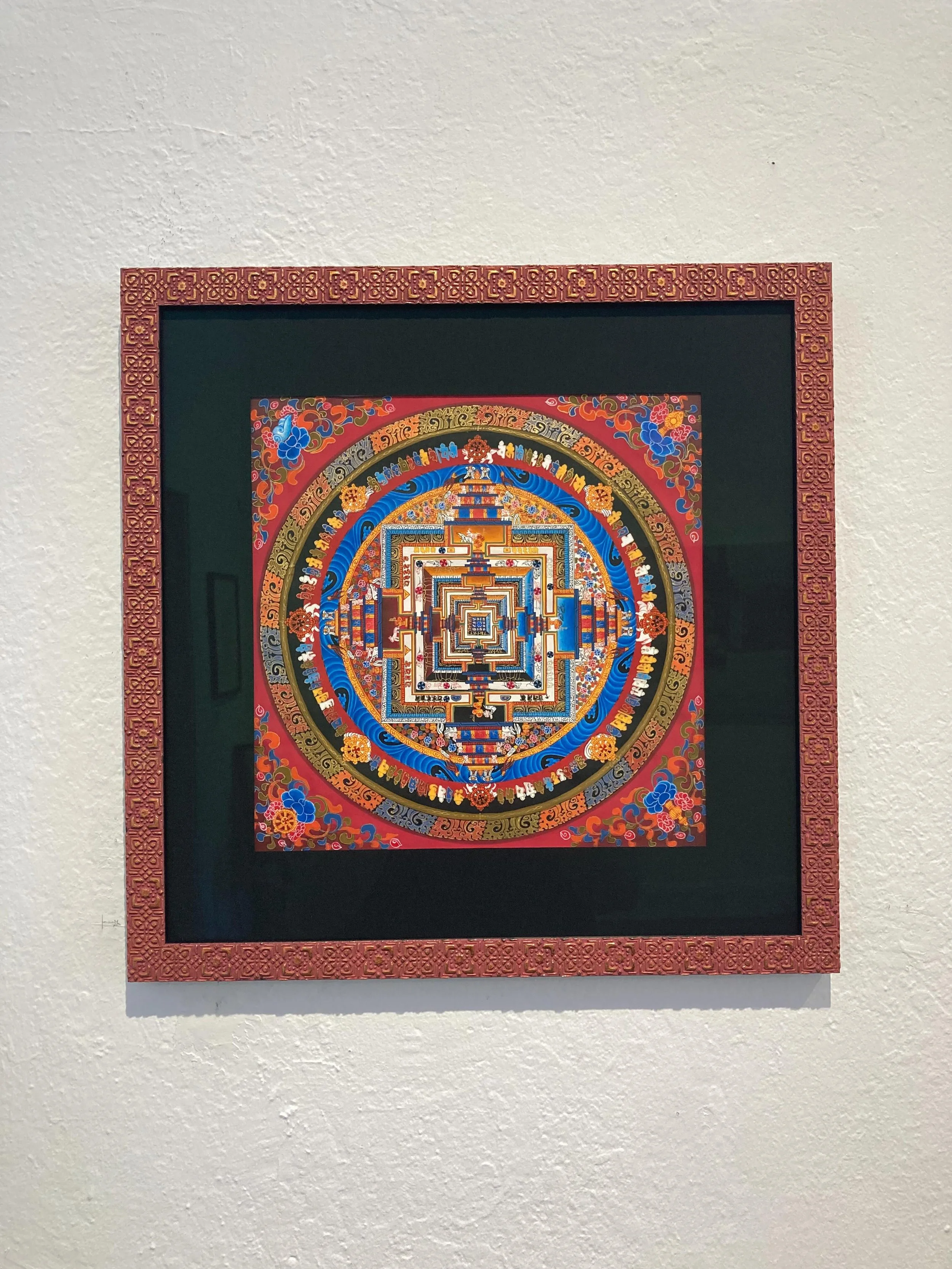 Here is a beautiful mandala framed in a colorful, patterned Bella moulding.  We often frame mandalas in gold frames because the gold is more neutral and doesn&rsquo;t take away from all of the color in the piece.  This red frame compliments the backg