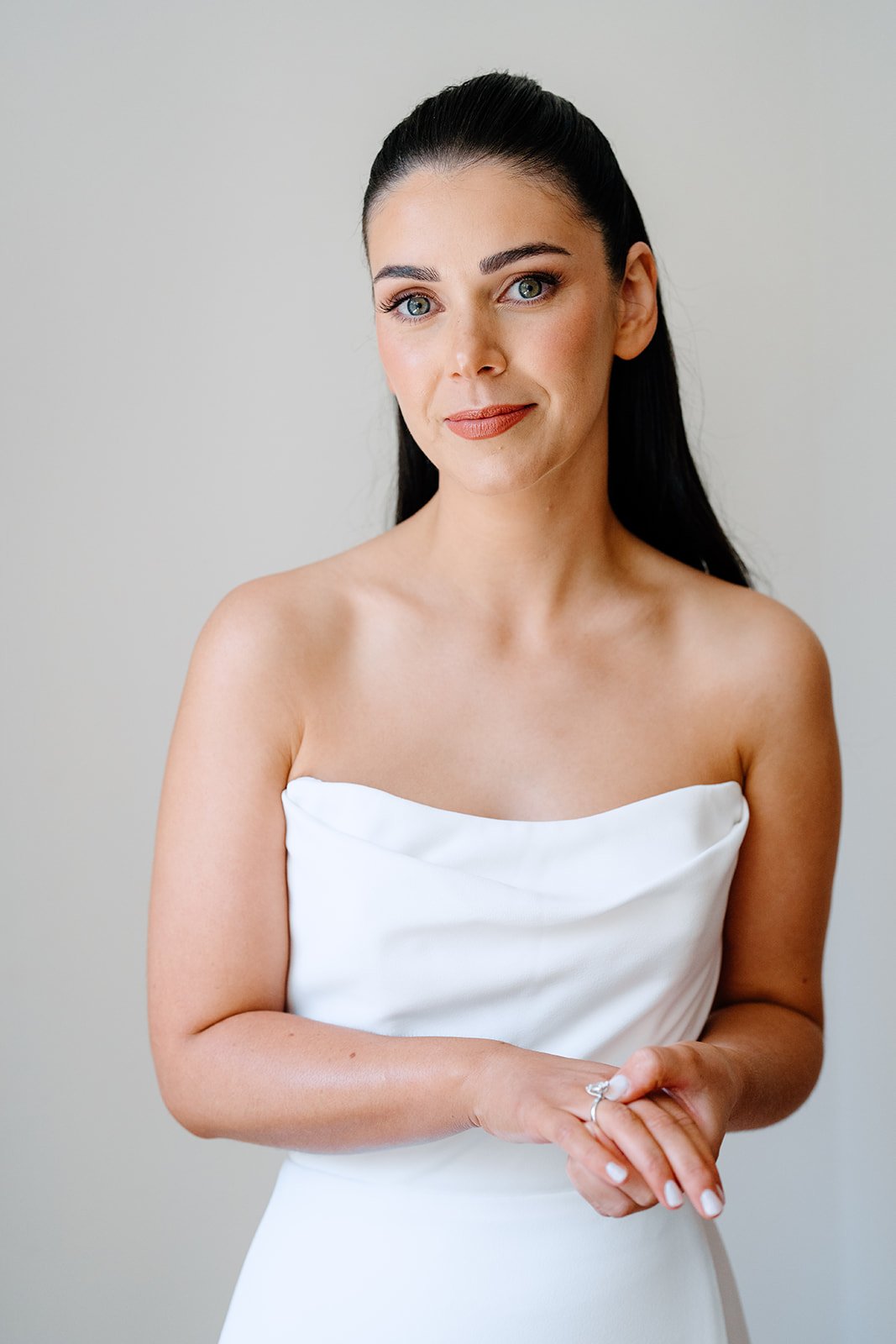 Woman in white sleeveless dress with dark hair