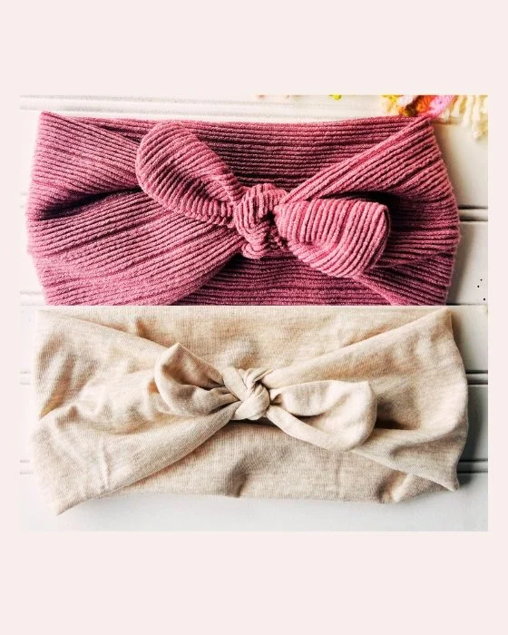 Two knotted headbands, one pink and one beige, on a white background.