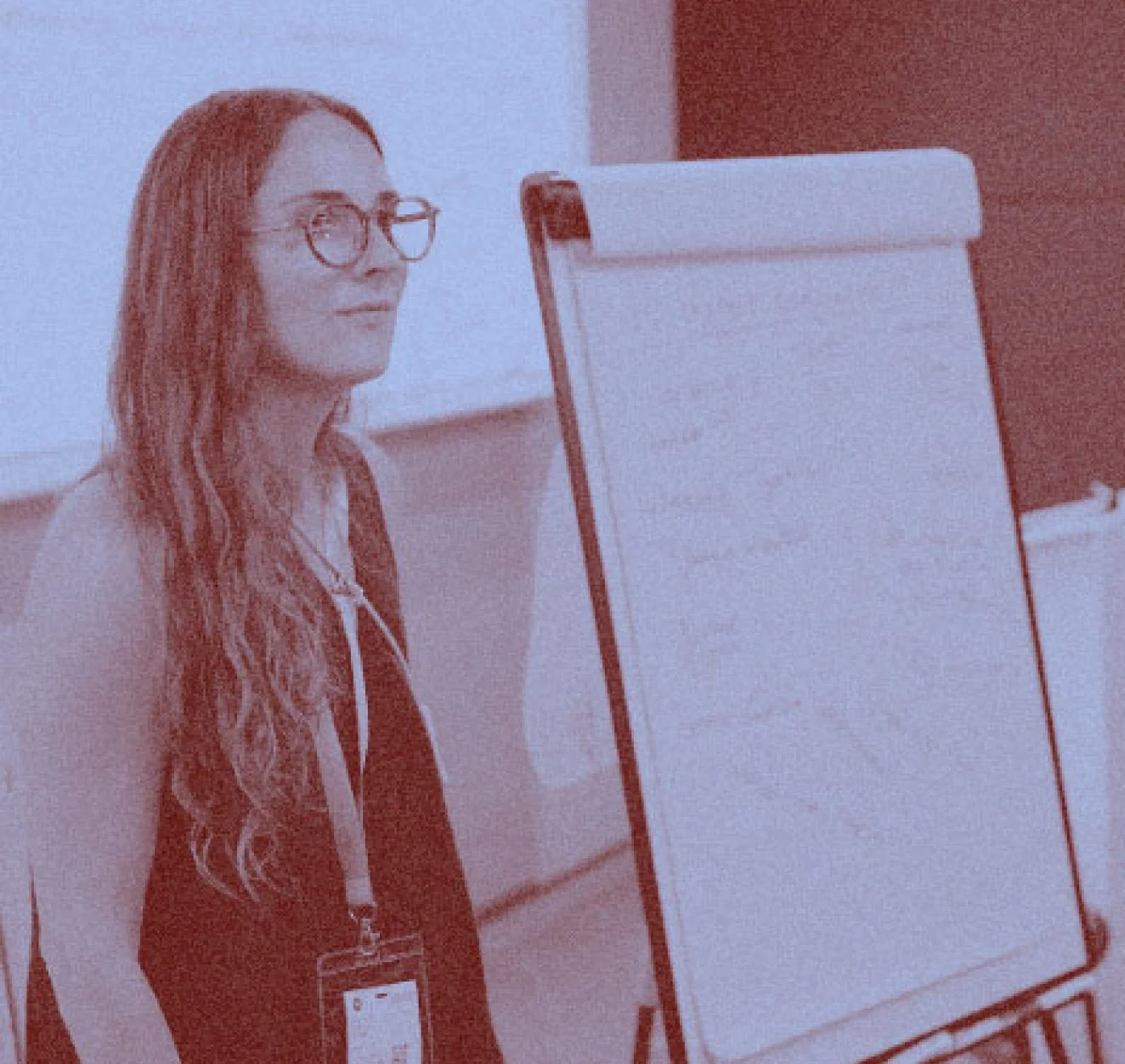 Photograph of Connie Flude presenting at a whiteboard. Duotone blue and grain effect applied.