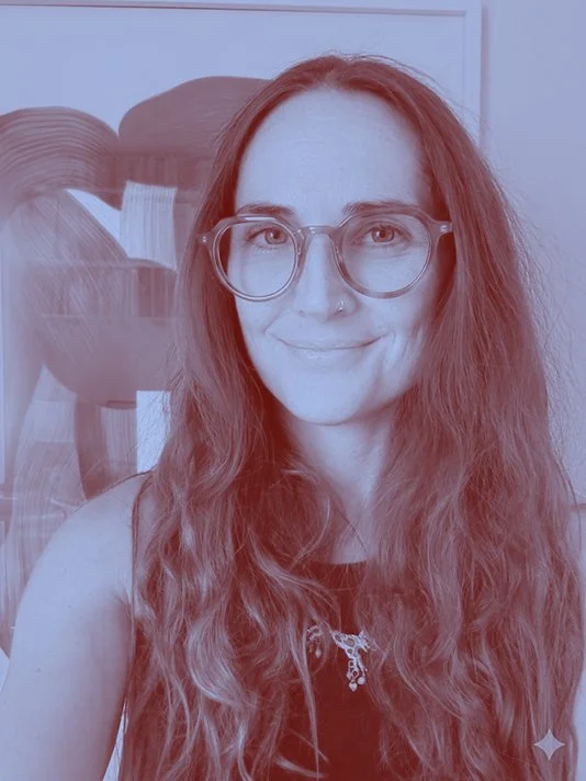 Connie Flude, founder of InsideOut, with long brown hair and glasses, smiling.  Duotone blue effect applied.