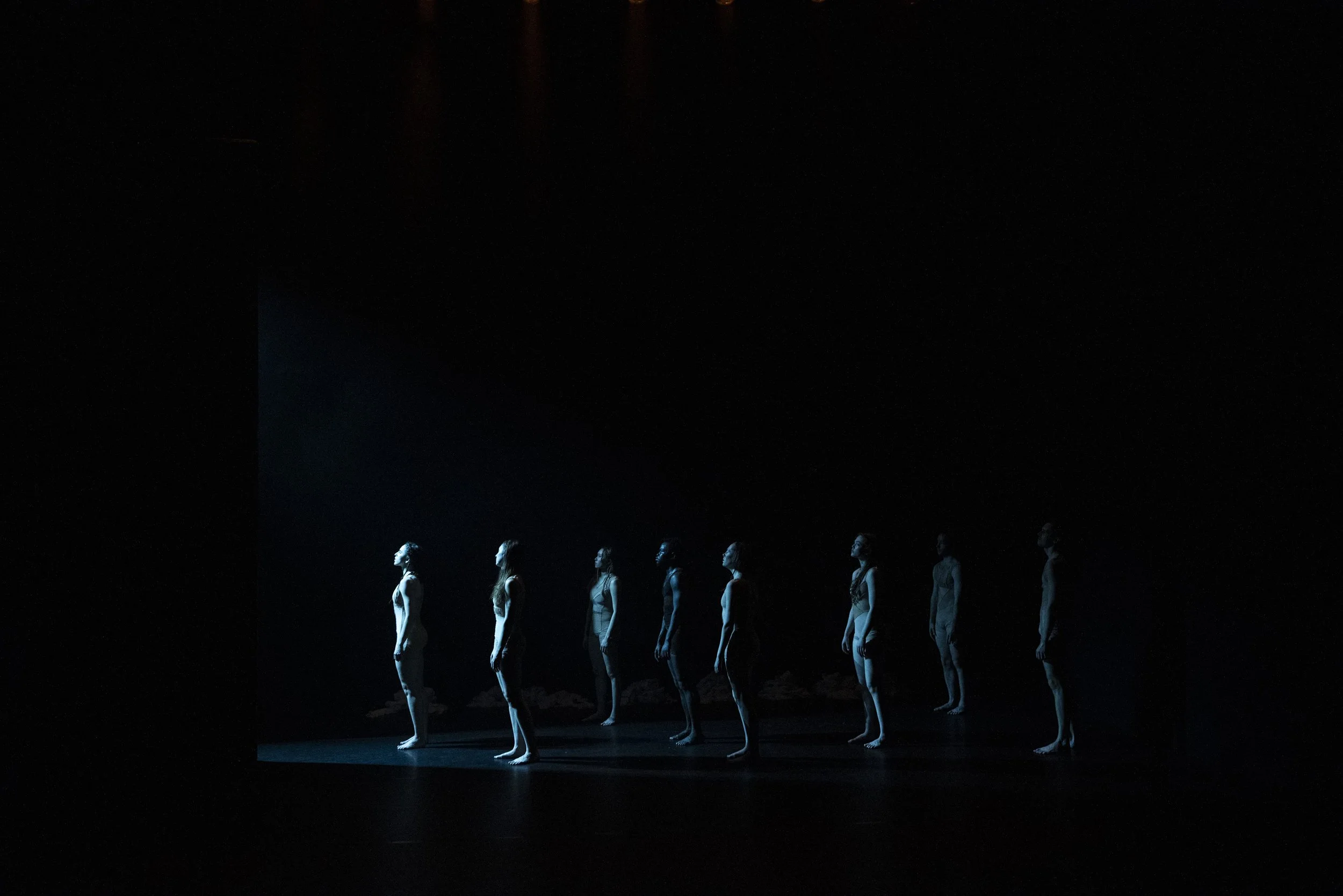 Dancers stood in a blue light.