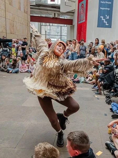 Dancer in motion in costume representing a bird.