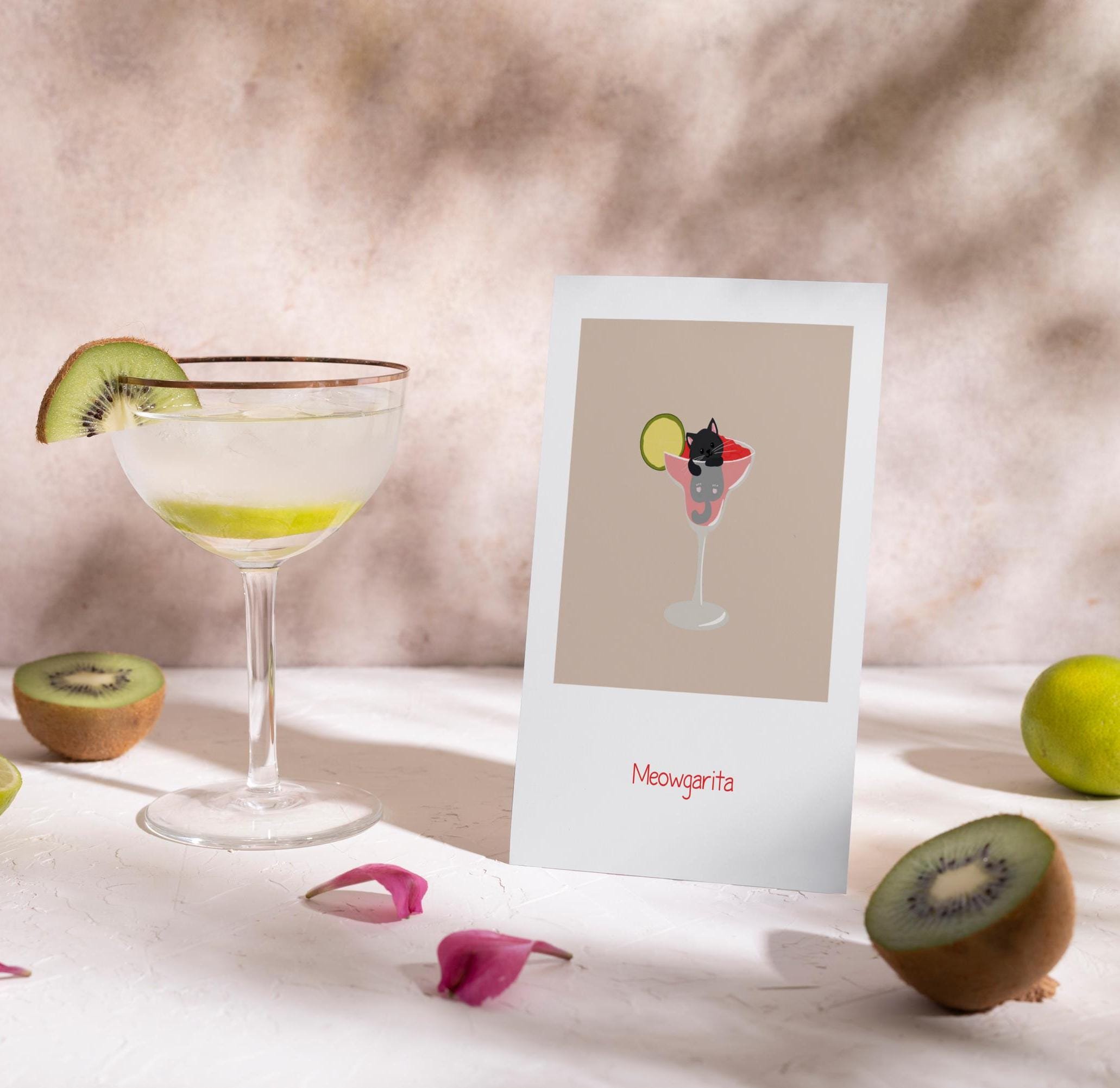 Ein Martini-Glas mit einer Kiwi-Garnitur und einem Farbfotomaterial, das ein Happy-Meowguratacocktail mit einem schwarz-weißen Katzenporträt in einem Drink zeigt, auf einem weißen Oberflächen mit Kiwi- und Limettenscheiben, rosa Blütenblättern.