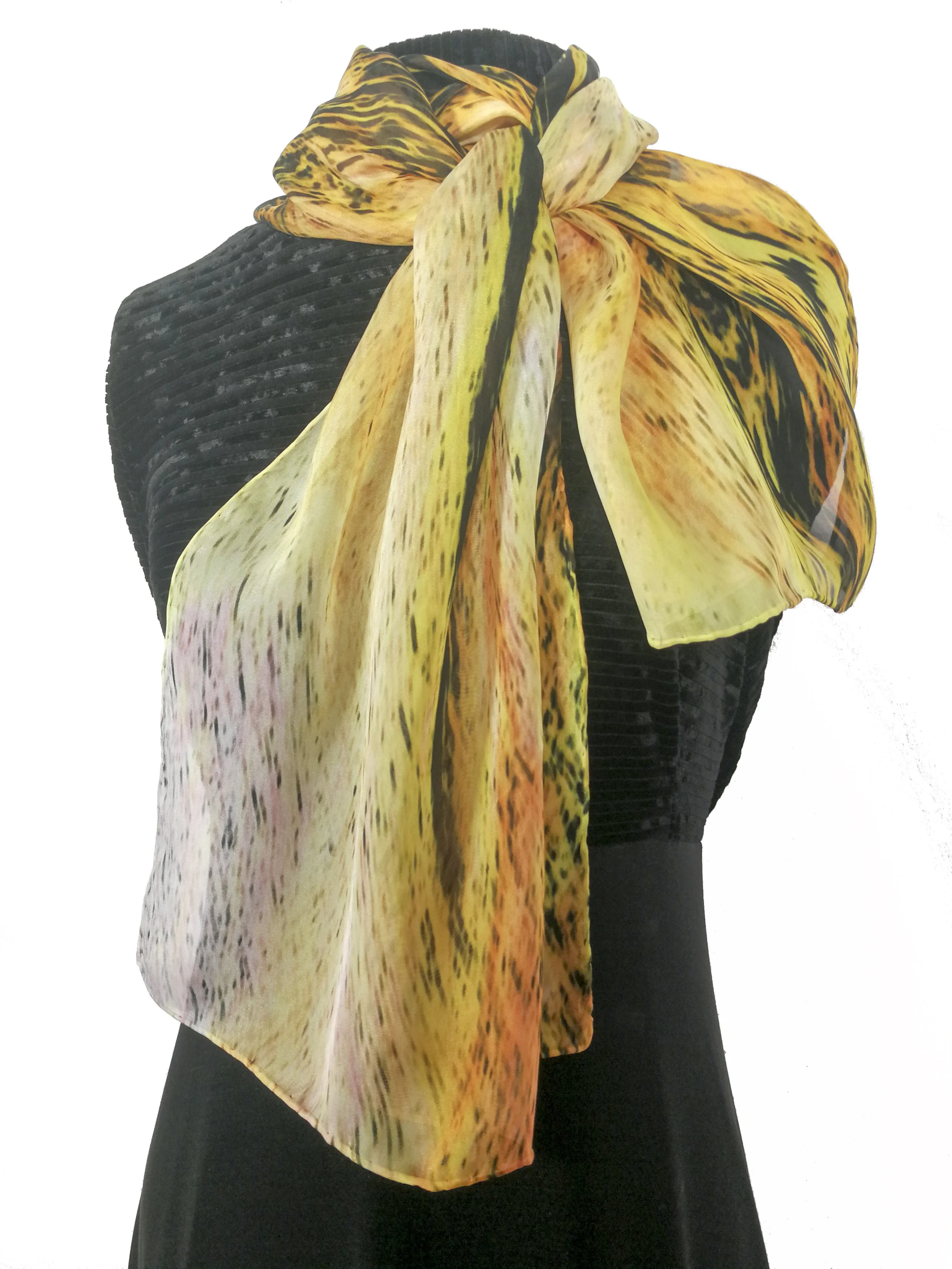 Black dress with a colorful, abstract scarf featuring yellow, orange, pink, and black streaks, tied in a knot at the shoulder.