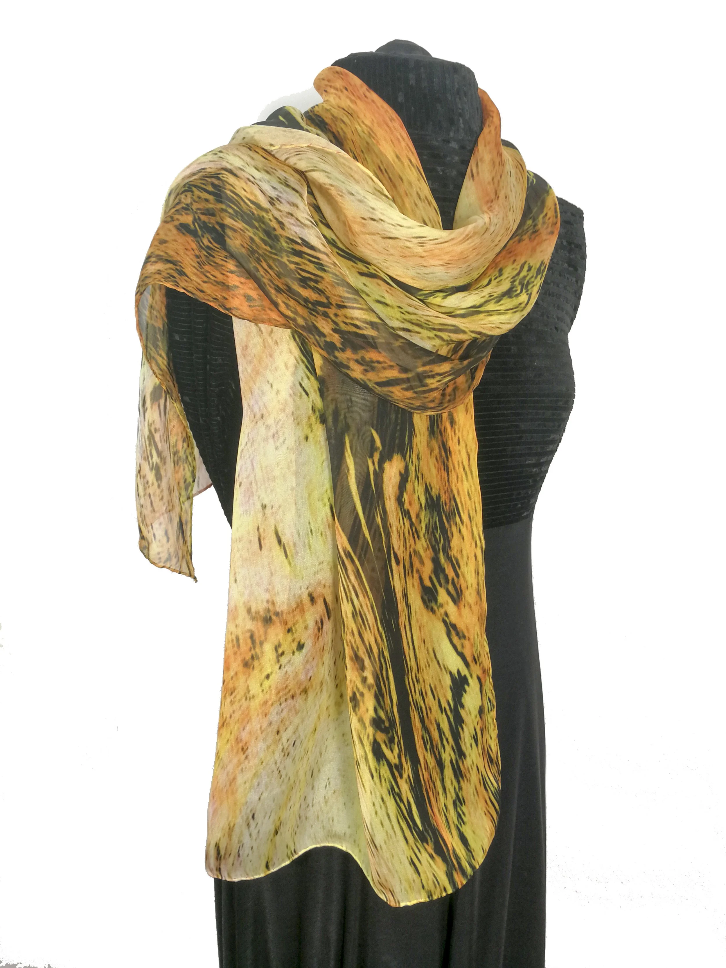 Two mannequins wearing black outfits; one with a colorful orange and yellow patterned scarf, the other with a matching scarf and a plain black hoodie.