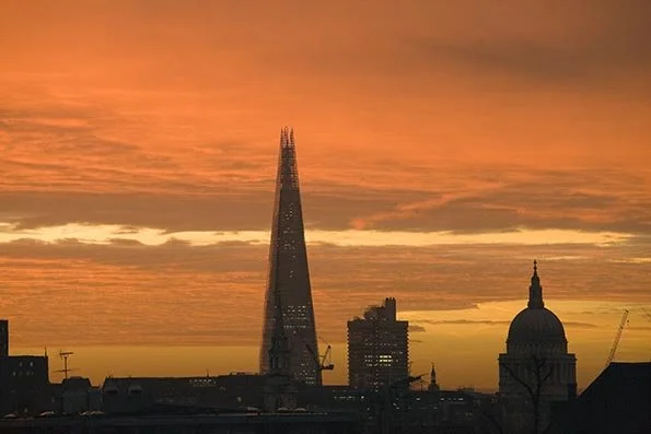Sunset over London skyline featuring The Shard and St. Paul's Cathedral.