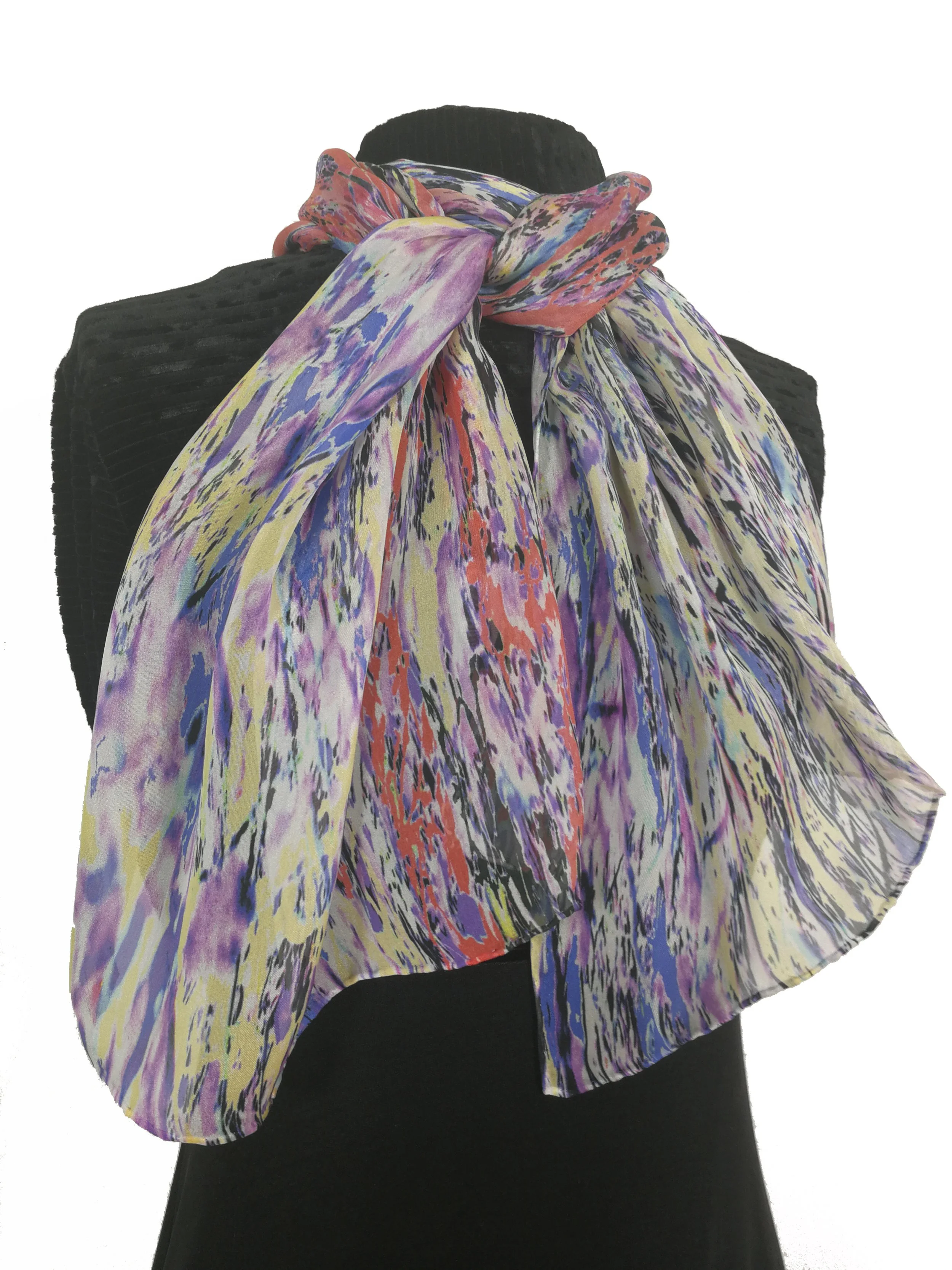 A person wearing a black turtleneck sweater and a colorful, abstract-patterned scarf tied around the neck.